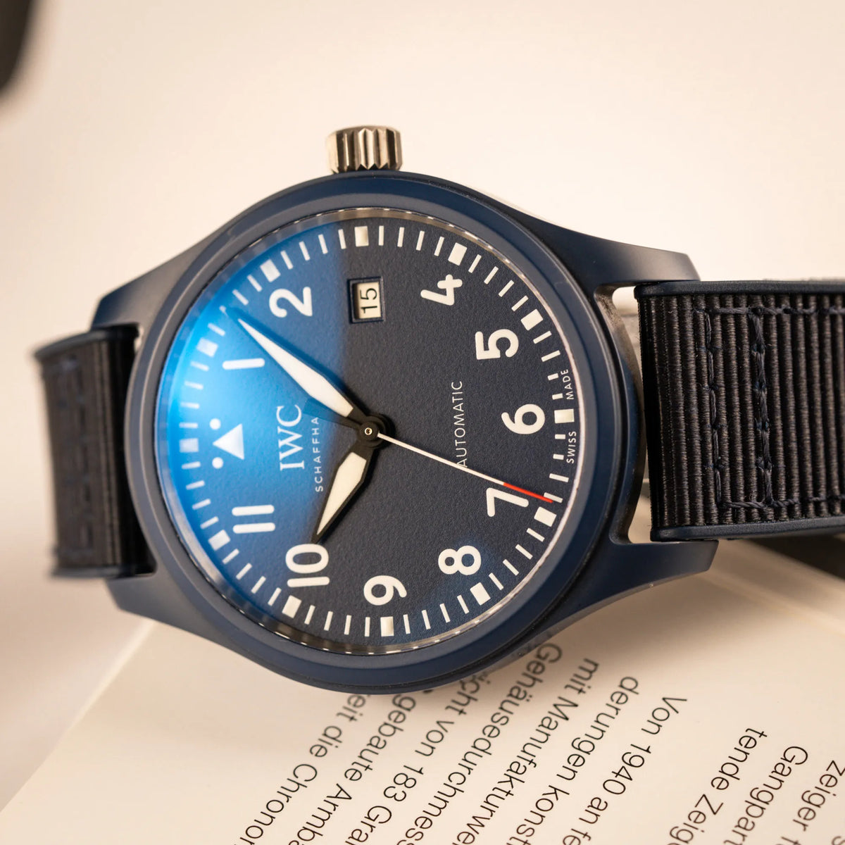 Produktfotografie der limitierten IWC Pilot's Watch IW328101 "Laureus Sport for Good" mit blauem Keramik-Gehäuse mit Lichtspiegelung im Uhrenglas