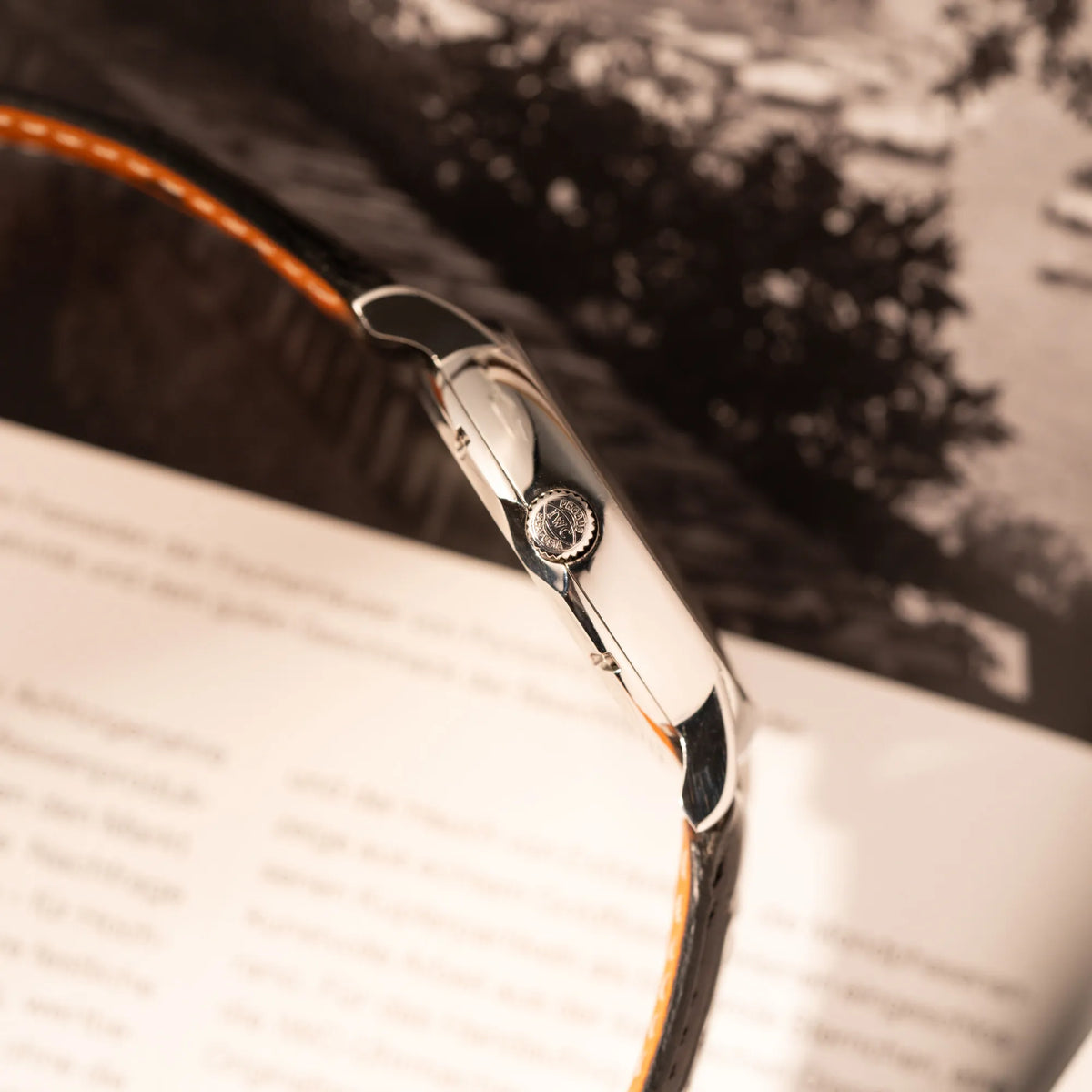 Produktfotografie der IWC Portofino Automatik IW356305 Armbanduhr mit minimalistischen, schwarzem Zifferblatt mit Stichindizes am schwarzen Lederband zeigt die Gehäuseflanke mit Aufzugsskrone