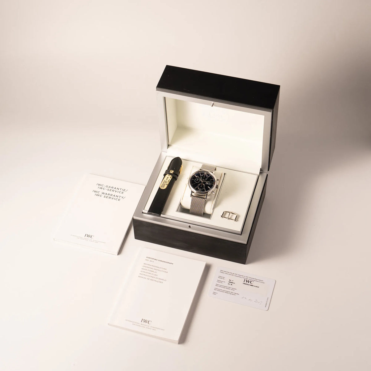 Lieferumfang zugehörig zu der IWC Portofino Chronograph der Referenz IW391002 mit schwarzem Zifferblatt an einem Mesh-Armband, betsehend aus Box, zusätzlichem schwarzen IWC-Lederband mit Dornschliesse, allen Booklets und originaler Garantiekarte