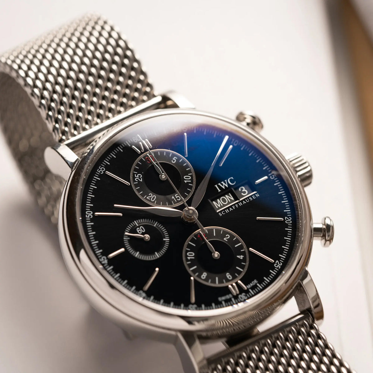 Detailaufnahme des IWC Portofino Chronograph der Referenz IW391002 mit schwarzem Zifferblatt an einem Mesh-Armband