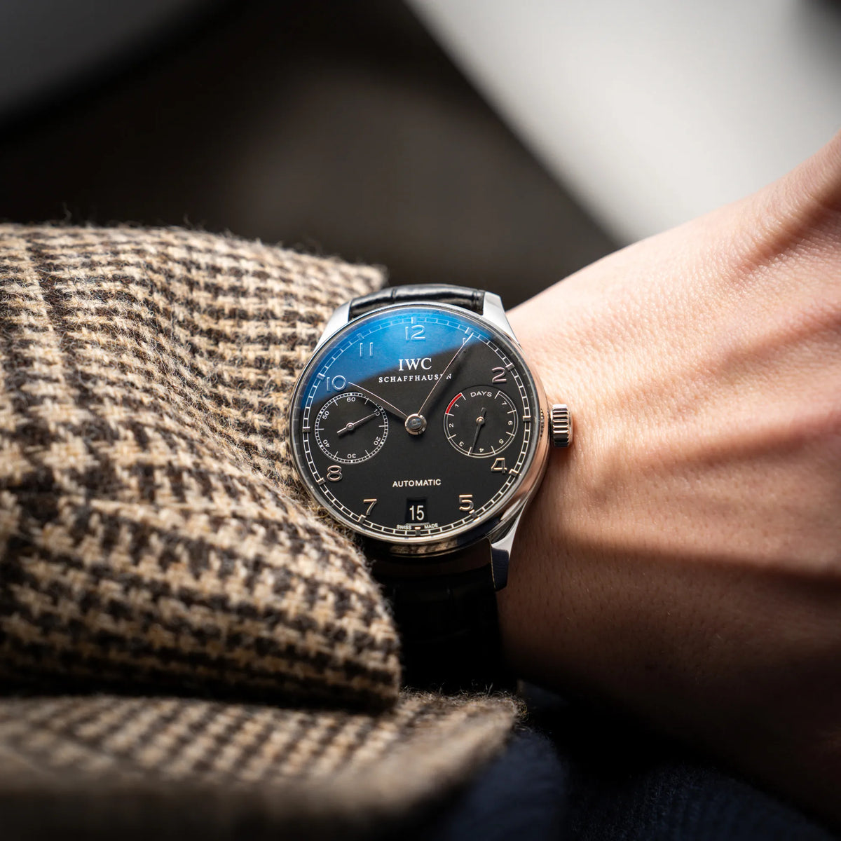 Wristshot mit der IWC Portugieser 7 Days IW500109 mit schwarzem Zifferblatt am schwarzen Lederband
