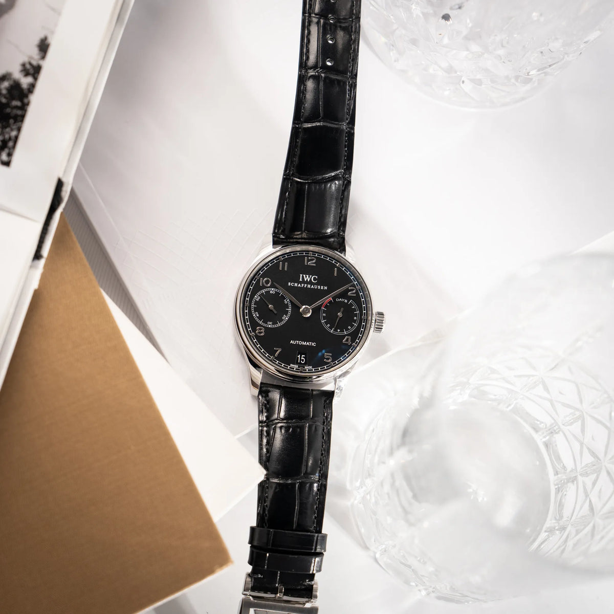Produktfotografie der IWC Portugieser 7 Days IW500109 mit schwarzem Zifferblatt am schwarzen Lederband