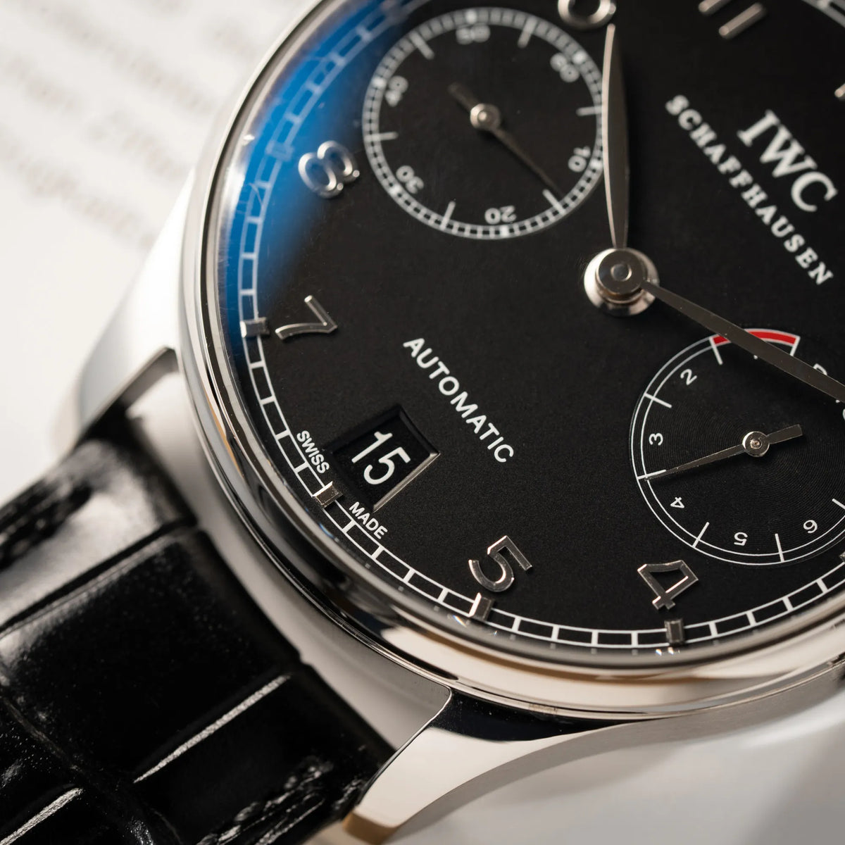 Detailaufnahme der IWC Portugieser 7 Days IW500109 mit schwarzem Zifferblatt am schwarzen Lederband mit Fokus auf dem Datumsfenster bei 6 Uhr