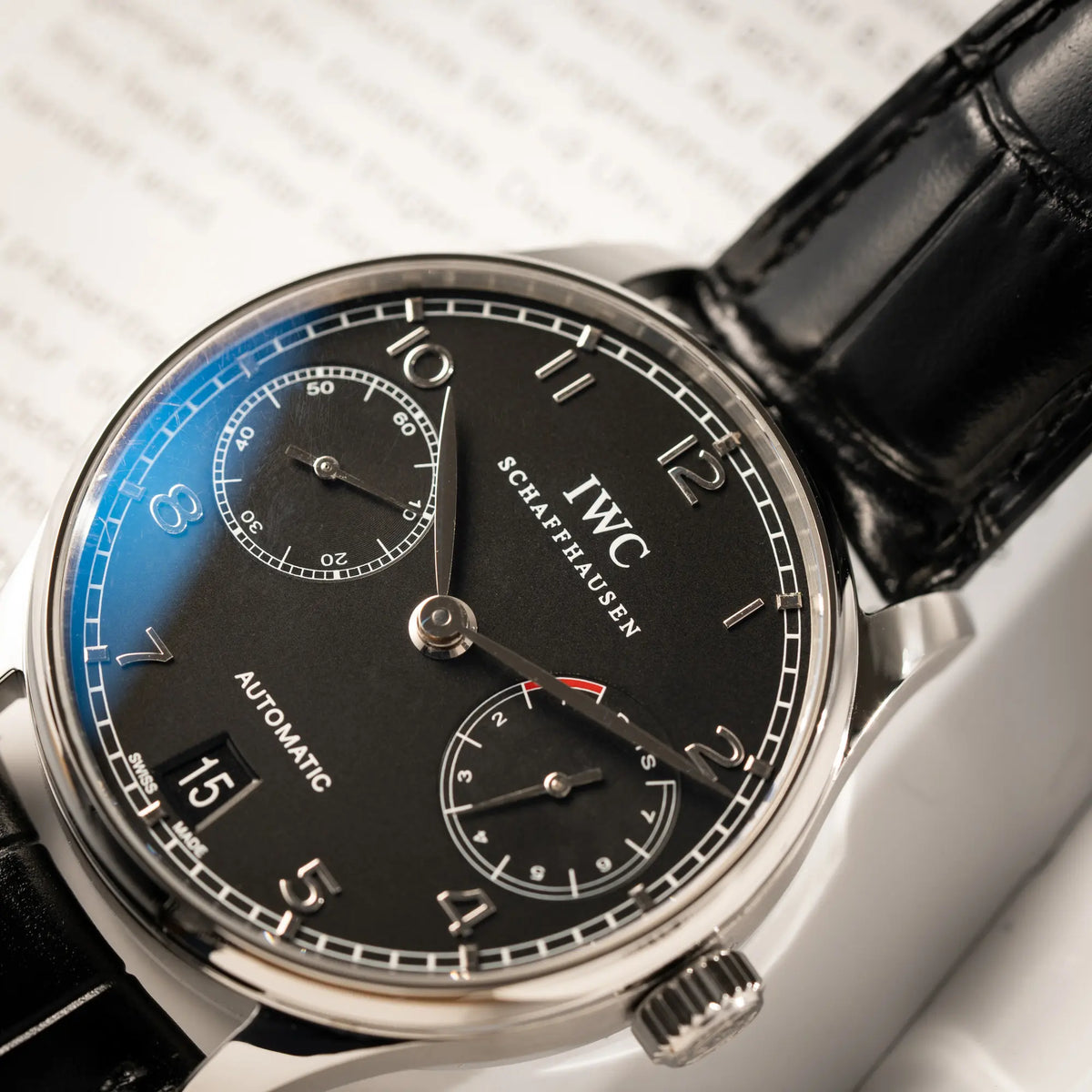 Detailaufnahme der IWC Portugieser 7 Days IW500109 mit schwarzem Zifferblatt am schwarzen Lederband
