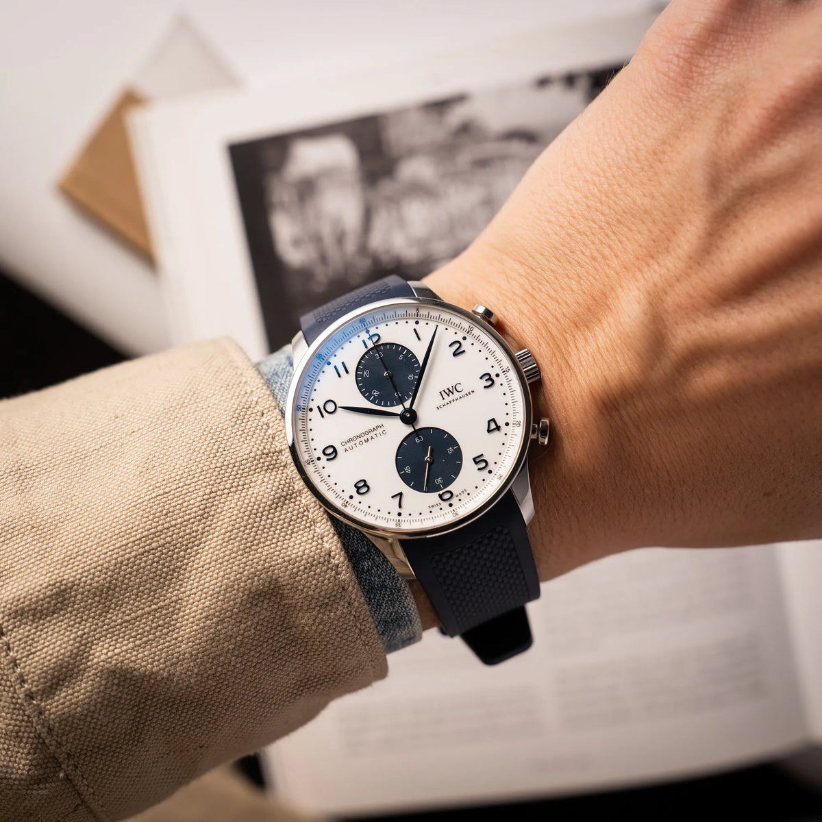 Wristshot mit der IWC Portugieser Chronograph 41 der Referenz IW371620 mit weißem Zifferblatt und dunkelblauen Totalisatoren am passenden dunkelblauen Kautschukarmband