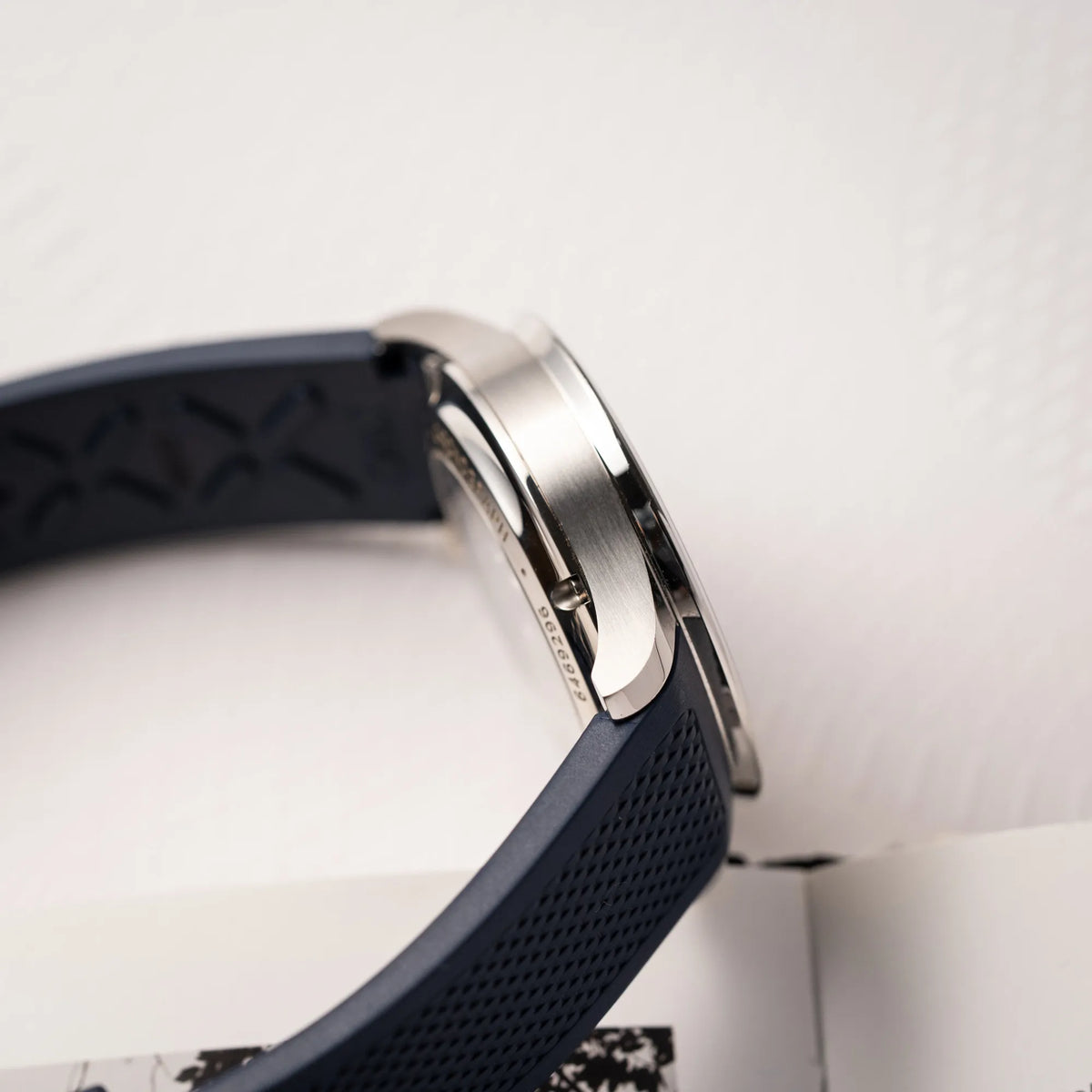 Seitliche Gehäuseflanke der IWC Portugieser Chronograph 41 der Referenz IW371620 mit weißem Zifferblatt und dunkelblauen Totalisatoren am passenden dunkelblauen Kautschukarmband