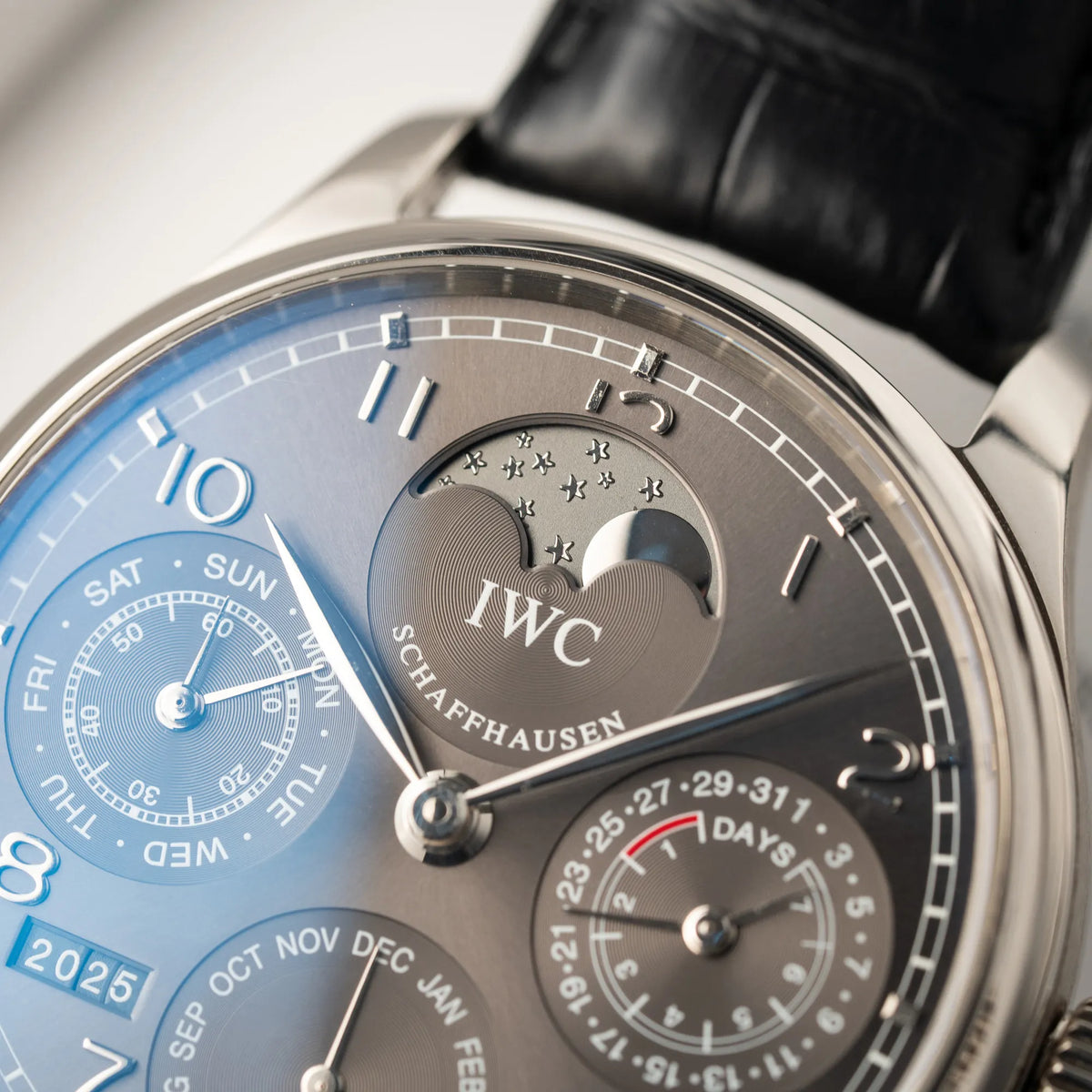 Makroaufnahme des IWC Portugieser Ewiger Kalender IW502307 mit 44m Weißgold-Gehäuse und anthrazit-farbenem Zifferblatt zeigt die Mondphase-Anzeige bei 12 Uhr mit Sternen-Details