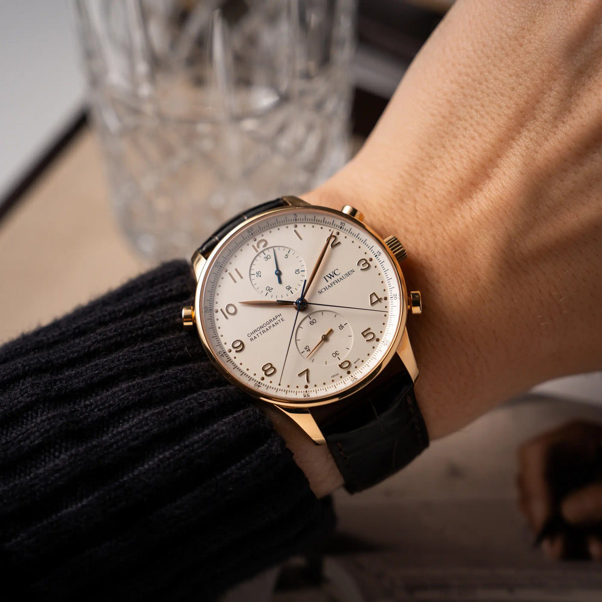 Mann trägt den IWC Portugieser Rattrapante Doppel-Chronograph IW3712 aus 18k Roségold mit weißem Zifferblatt am braunen Lederband an seinem Handgelenk