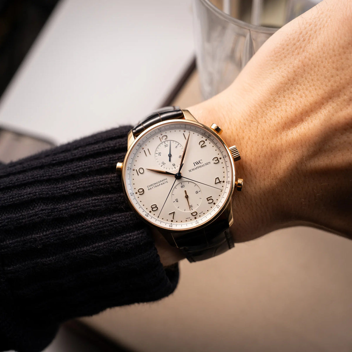 Wristshot mit dem IWC Portugieser Rattrapante Doppel-Chronograph IW3712 aus 18k Roségold mit weißem Zifferblatt am braunen Lederband