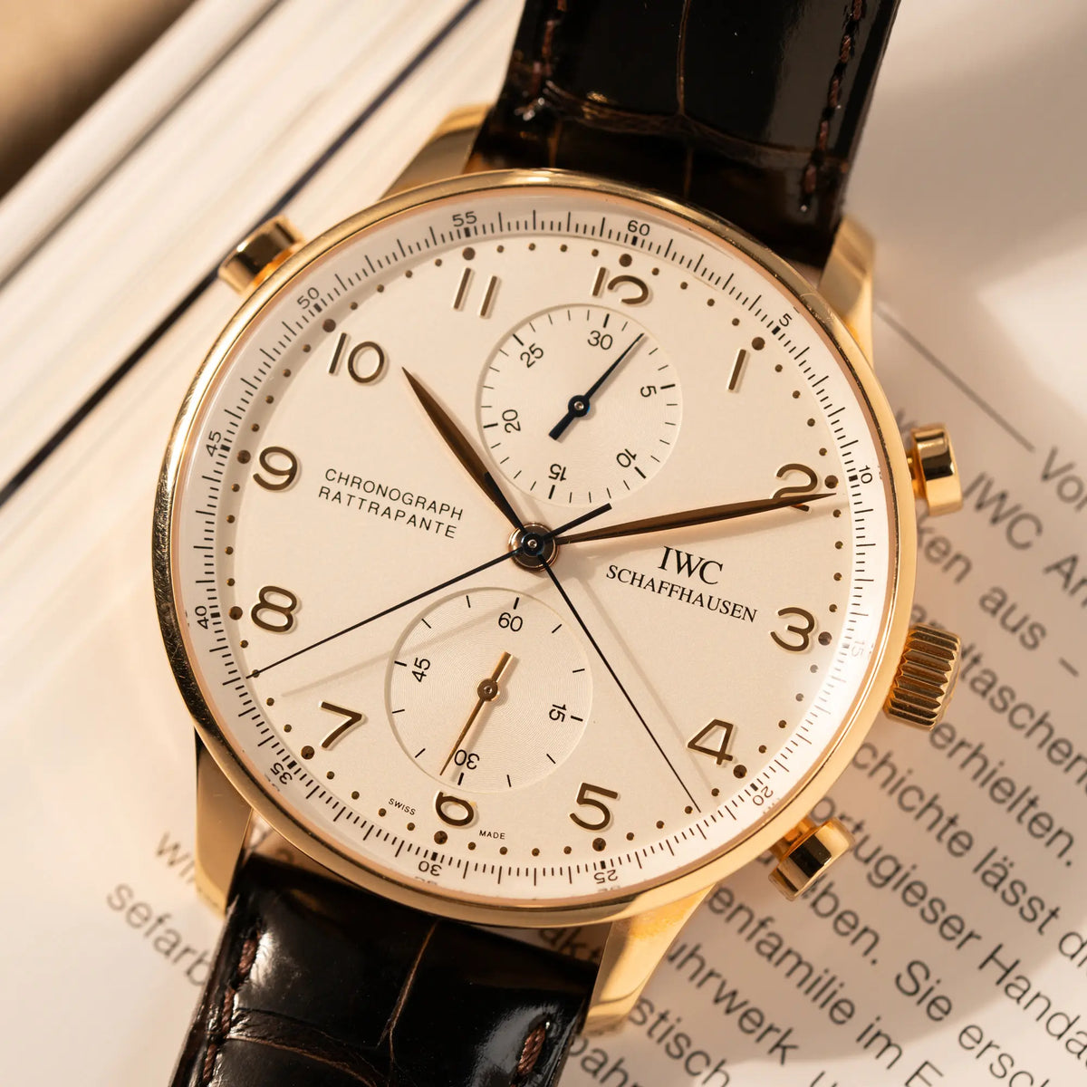 Detailaufnahme des IWC Portugieser Rattrapante Doppel-Chronograph IW3712 aus 18k Roségold mit weißem Zifferblatt am braunen Lederband