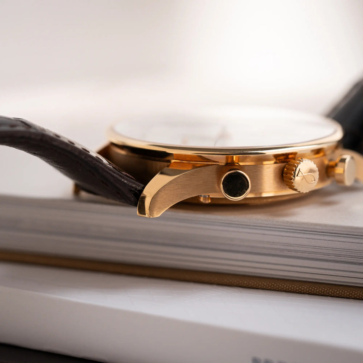 Produktfotografie des IWC Portugieser Rattrapante Doppel-Chronograph IW3712 aus 18k Roségold mit weißem Zifferblatt am braunen Lederband zeigt den rechten unteren Bandanstoß im Detail