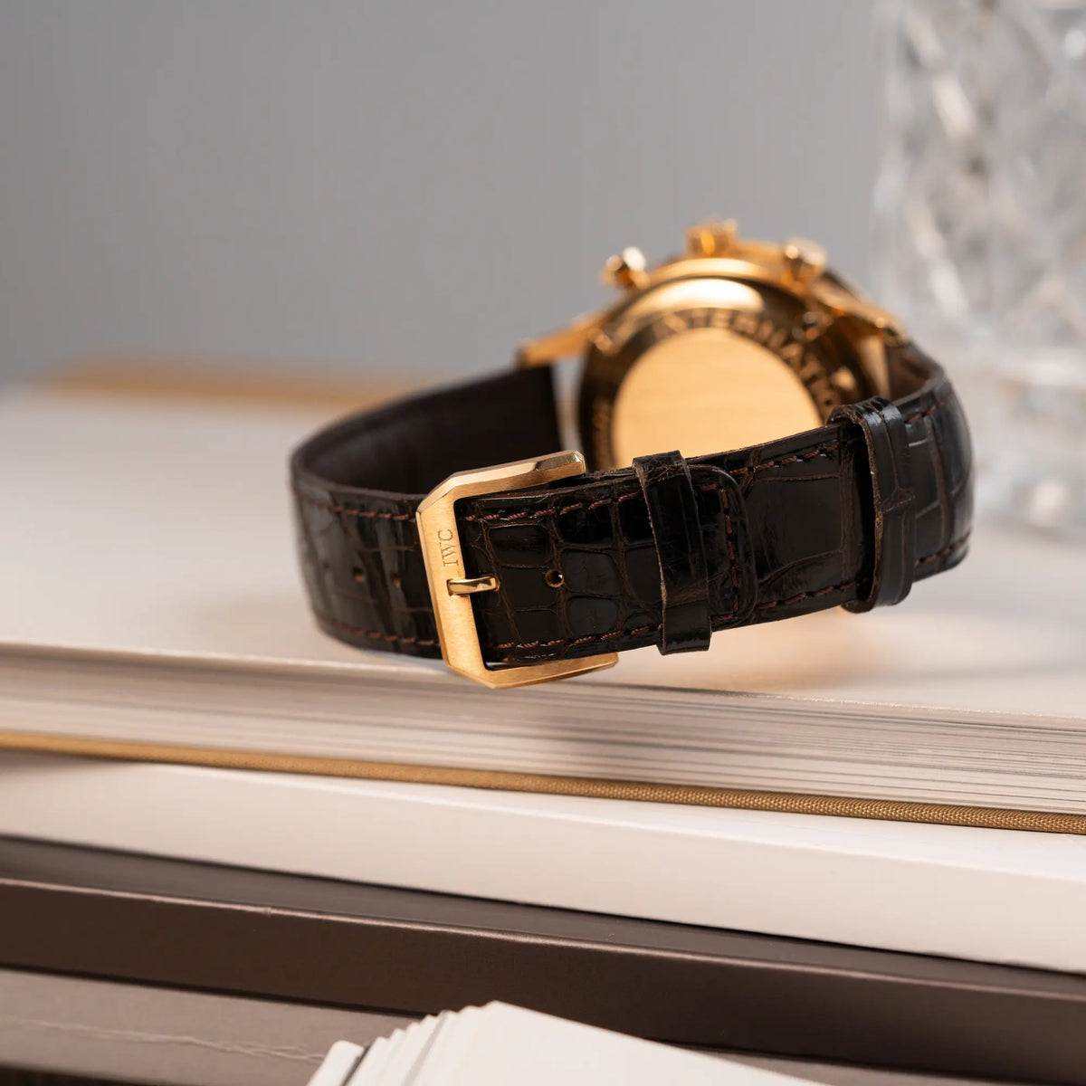 Produktfotografie des IWC Portugieser Rattrapante Doppel-Chronograph IW3712 aus 18k Roségold mit weißem Zifferblatt zeigt das montierte, braune, originale IWC-Lederband und die rosegoldene Dornschliesse
