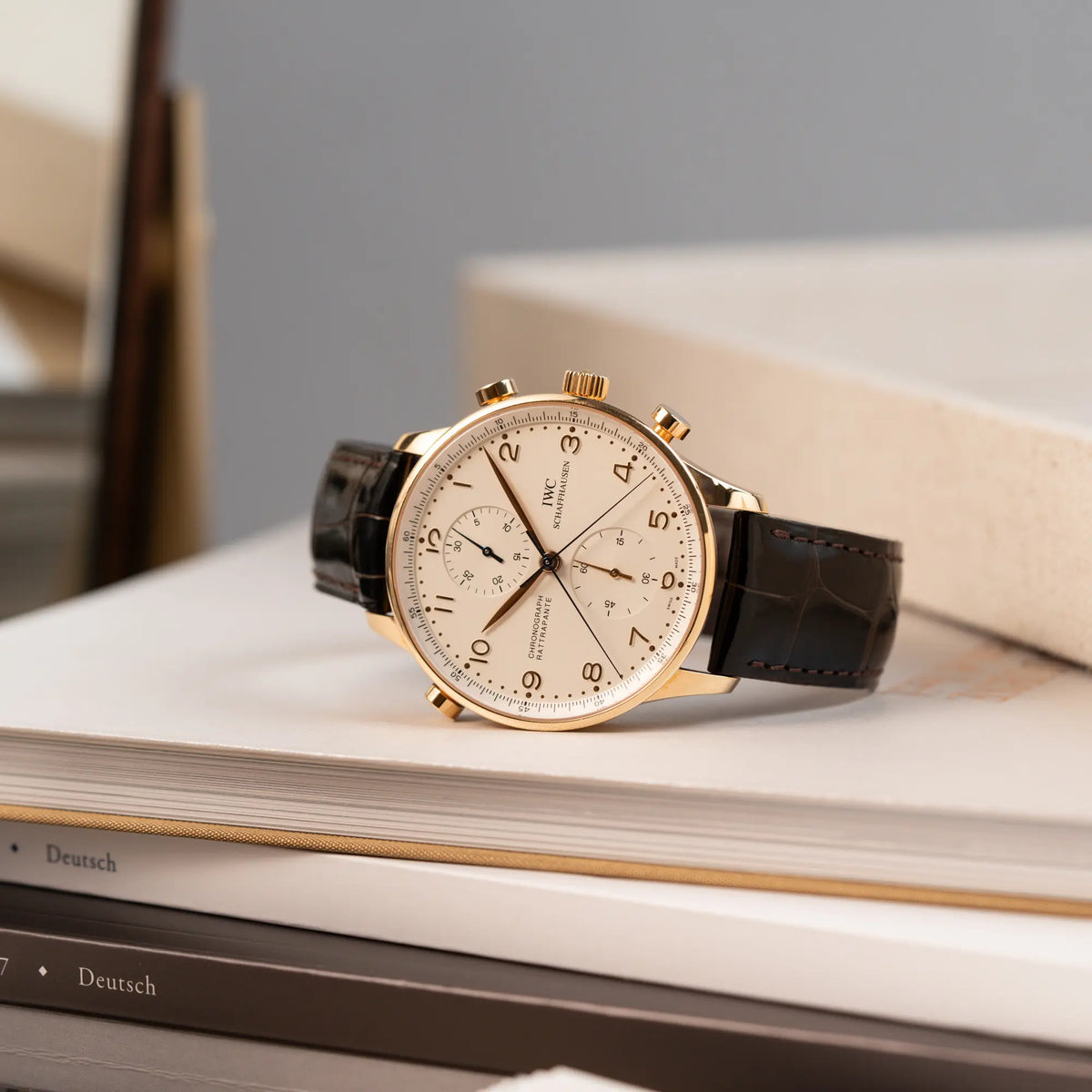 Produktfotografie des IWC Portugieser Rattrapante Doppel-Chronograph IW3712 aus 18k Roségold mit weißem Zifferblatt am braunen Lederband