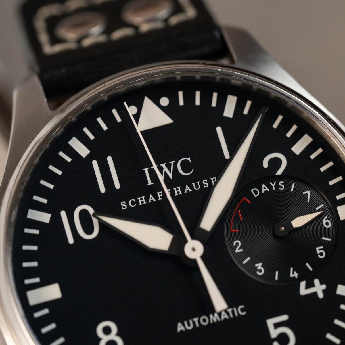 Detailaufnahme der IWC Big Pilot 46 Armbanduhr der Referenz IW500401 mit schwarzem Zifferblatt und der Power-Reserve-Anzeige bei 3 Uhr mit Fokus auf dem oberen Teil der Lünette