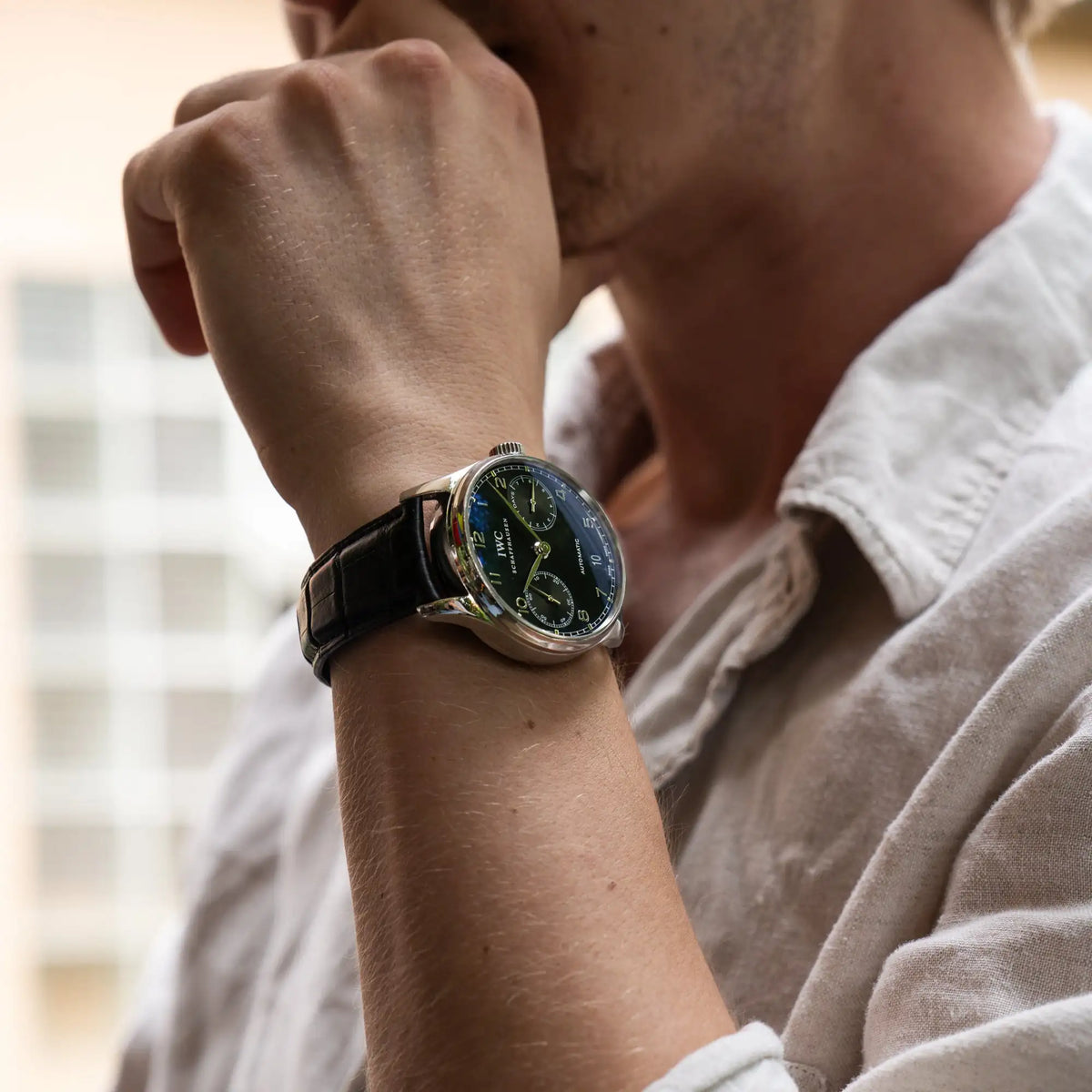Bild der Portugieser 7 Days Automatic IW500109 Uhr von IWC Schaffhausen am schwarzen Lederband mit schwarzem Zifferblatt an einem Männerhandgelenk