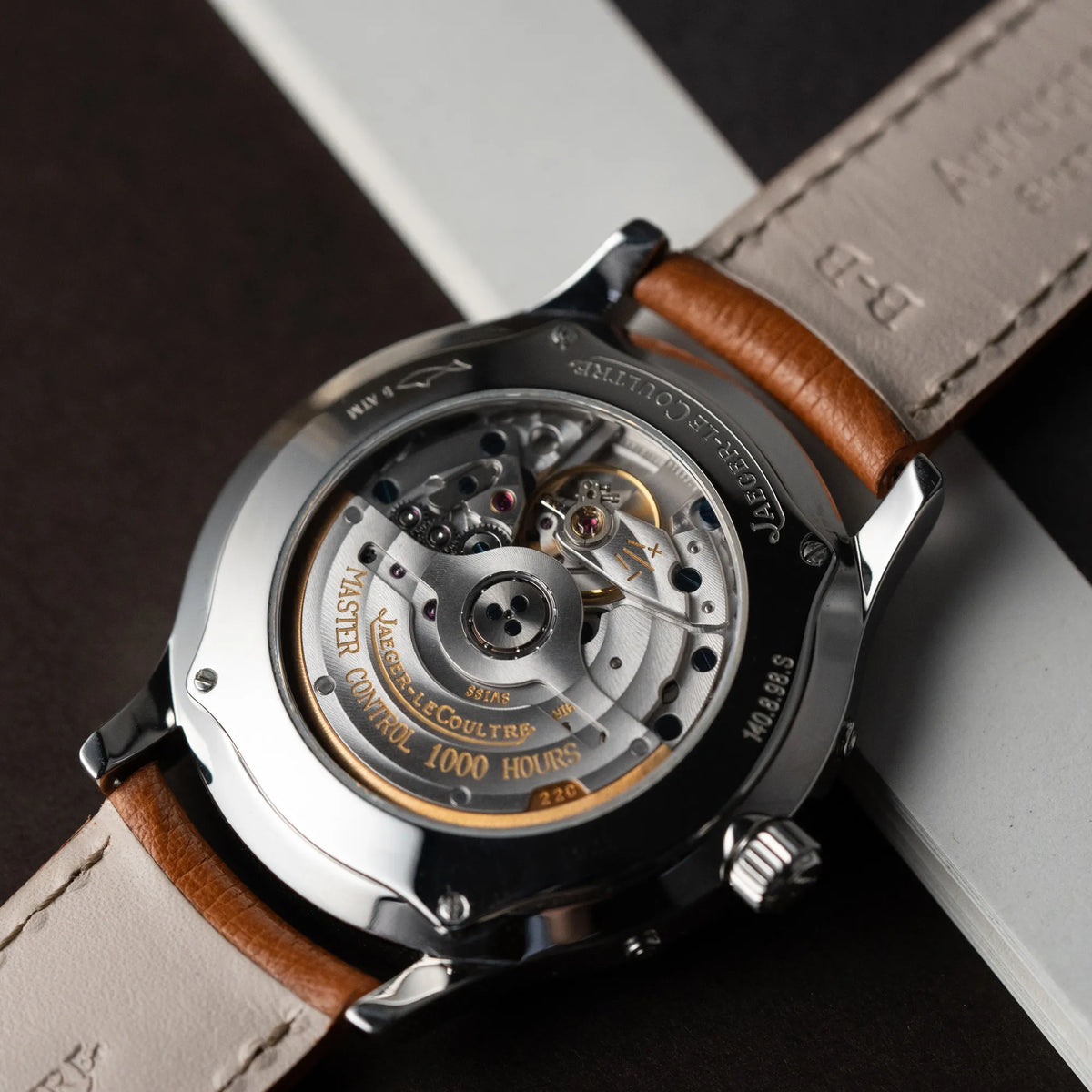 Detailaufnahme des Glasbodens der Jaeger LeCoultre Master Control Calender Moonphase mit silbernem Zifferblatt an einem braunen JLC-Lederband mit Blick auf das automatische Caliber 891