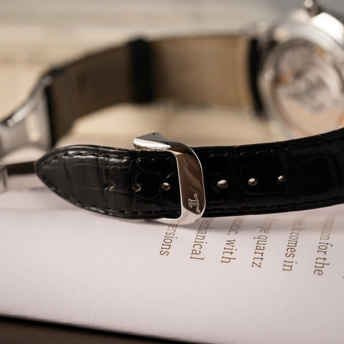 Detailaufnahme der originalen Faltschliesse mir JLC-Logo von der der Jaeger-LeCoultre Master Control Moonphase Calendar mit schwarzem Zifferblatt am schwarzen Lederband