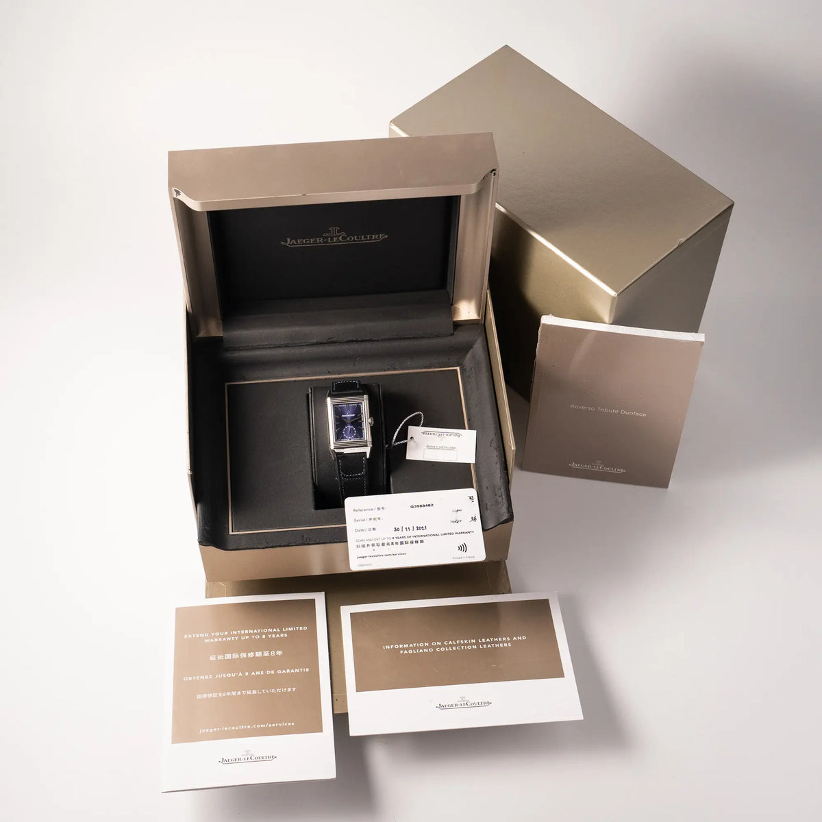 Lieferumfang zu der Jaeger-LeCoultre Reverso Duoface Q3988482 mit blauem Zifferblatt und weißem Night-and-Day-Zifferblatt am schwarzen Lederband, betsehdn aus Box mit Umkarton, Booklets, Hangtag und originaler Garantiekarte