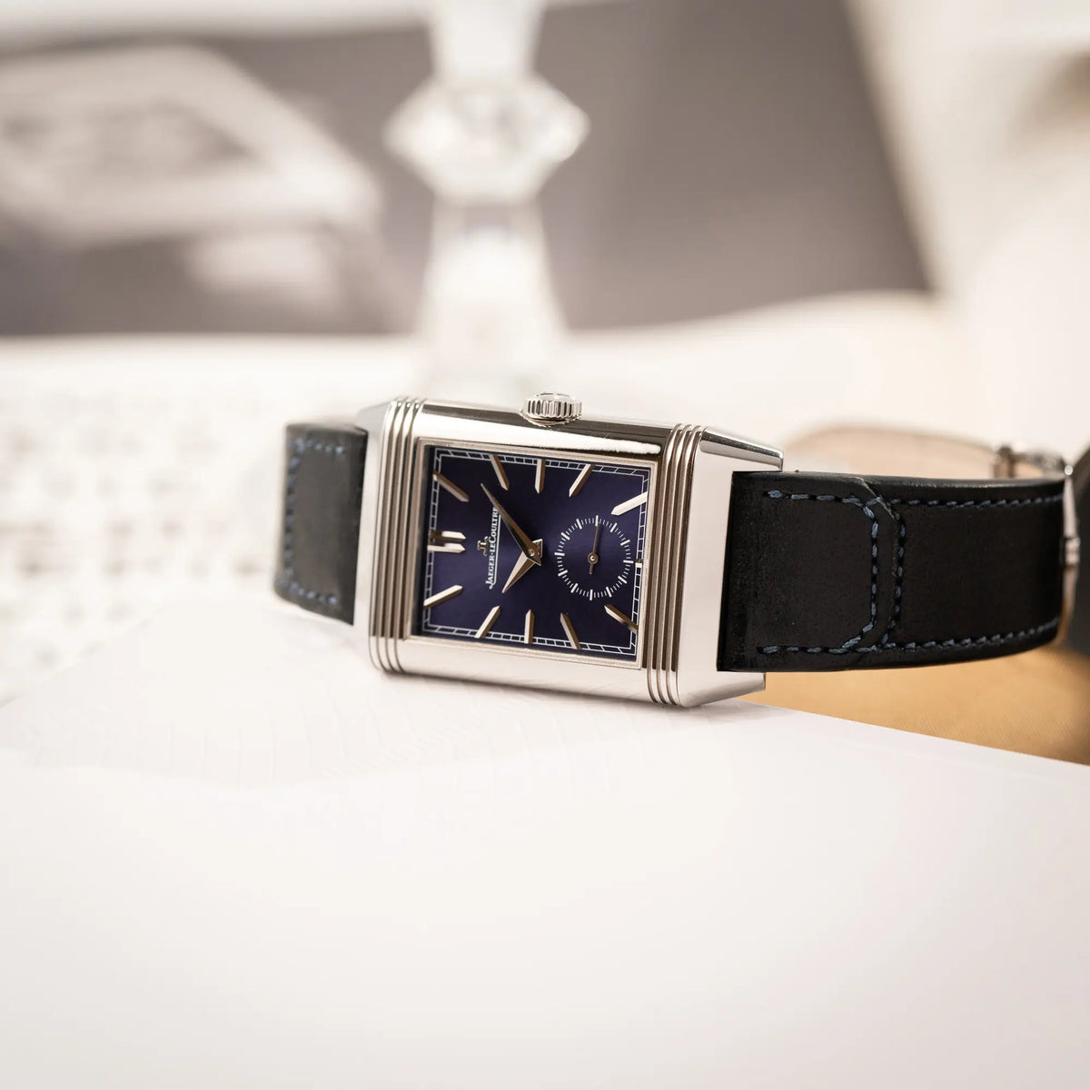 Produktfotografie der Jaeger-LeCoultre Reverso Duoface Q3988482 mit blauem Zifferblatt und weißem Night-and-Day-Zifferblatt am schwarzen Lederband