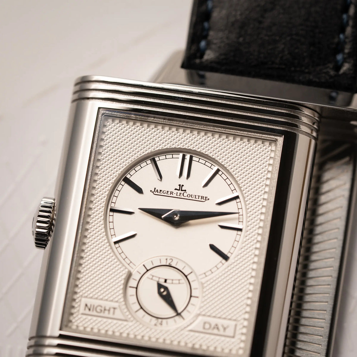 Detailaufnahme des weißen guillochiertem Zifferblatts von der Jaeger-LeCoultre Reverso Duoface Q3988482 mit blauem Zifferblatt und weißem Night-and-Day-Zifferblatt am schwarzen Lederband