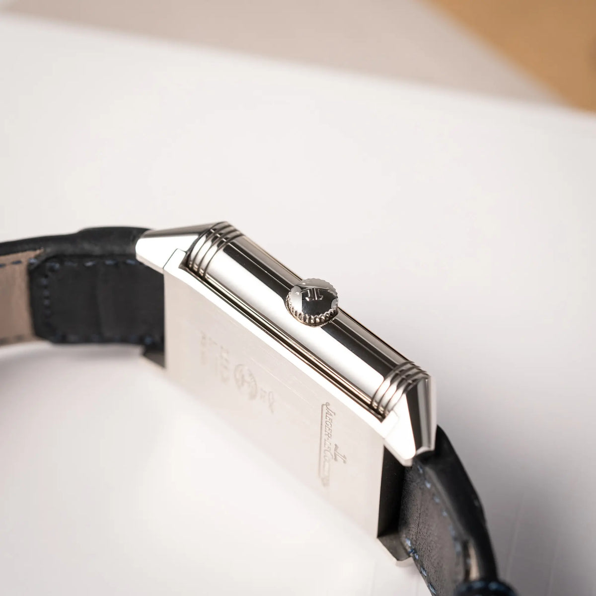 Seitliche Gehäuseflanke mit Blick auf die Aufzugskrone von der Jaeger-LeCoultre Reverso Duoface Q3988482 mit blauem Zifferblatt und weißem Night-and-Day-Zifferblatt am schwarzen Lederband