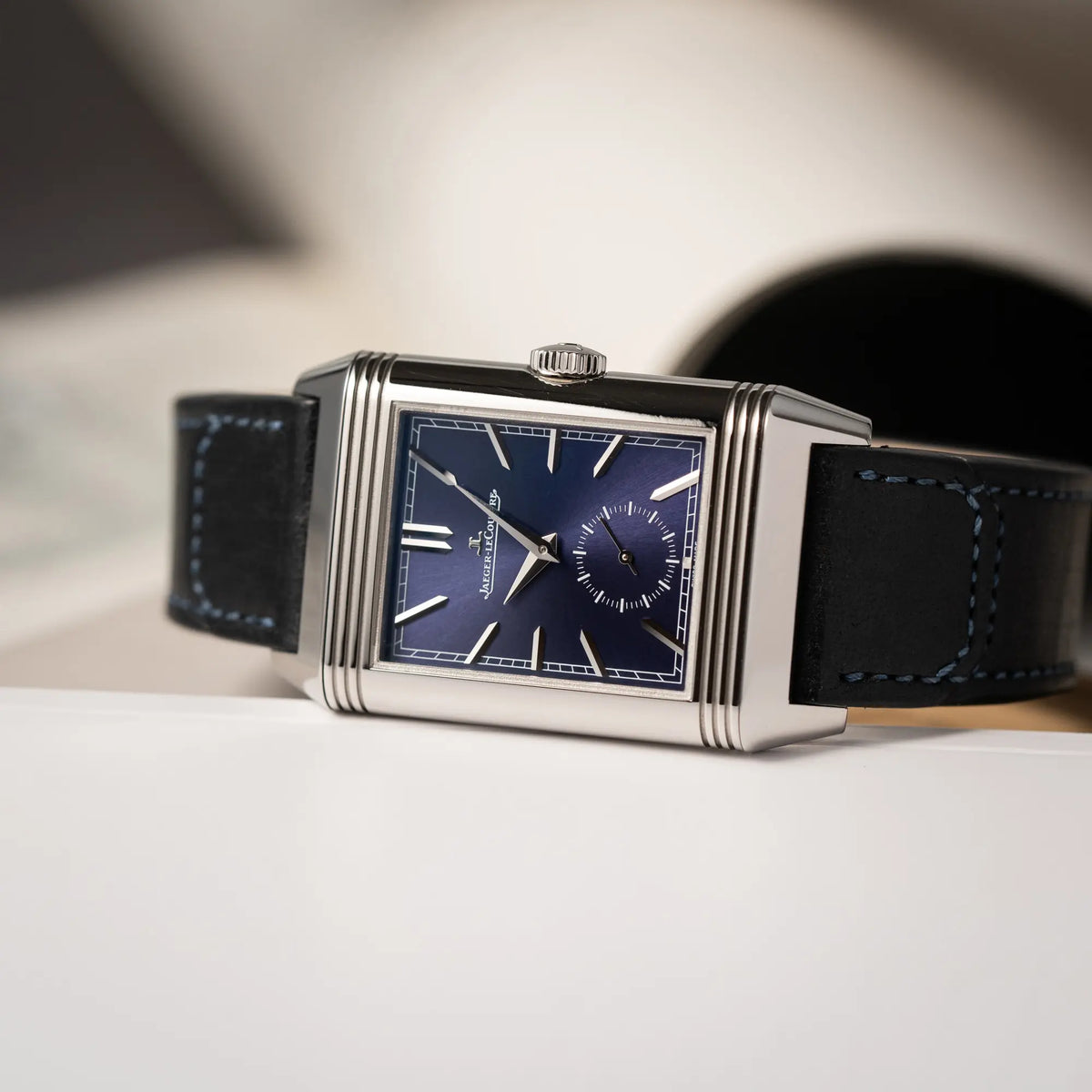 Detailaufnahme der Jaeger-LeCoultre Reverso Duoface Q3988482 mit blauem Zifferblatt und weißem Night-and-Day-Zifferblatt am schwarzen Lederband