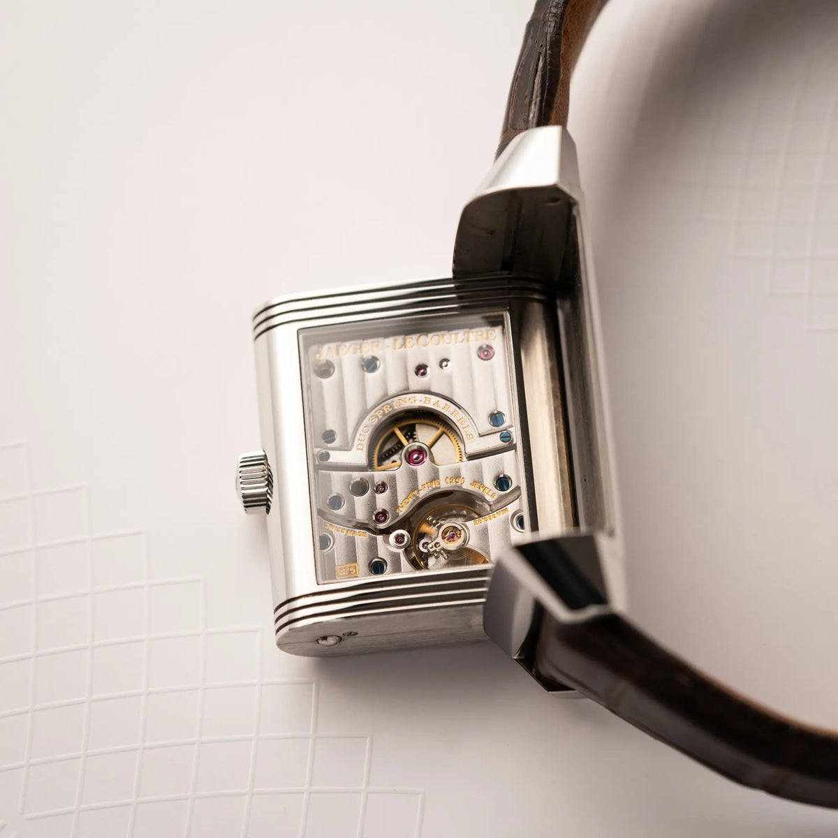 Gehäuseboden mit Sichtglas zeigt das Handaufzug-Kaliber der Jaeger-LeCoultre Reverso Grande Date der Referenz 240.8.15 mit silberfarbenem Zifferblatt und Großdatums-Anzeige, kleiner Sekunde und Gangreserve-Anzeige am braunen Lederband