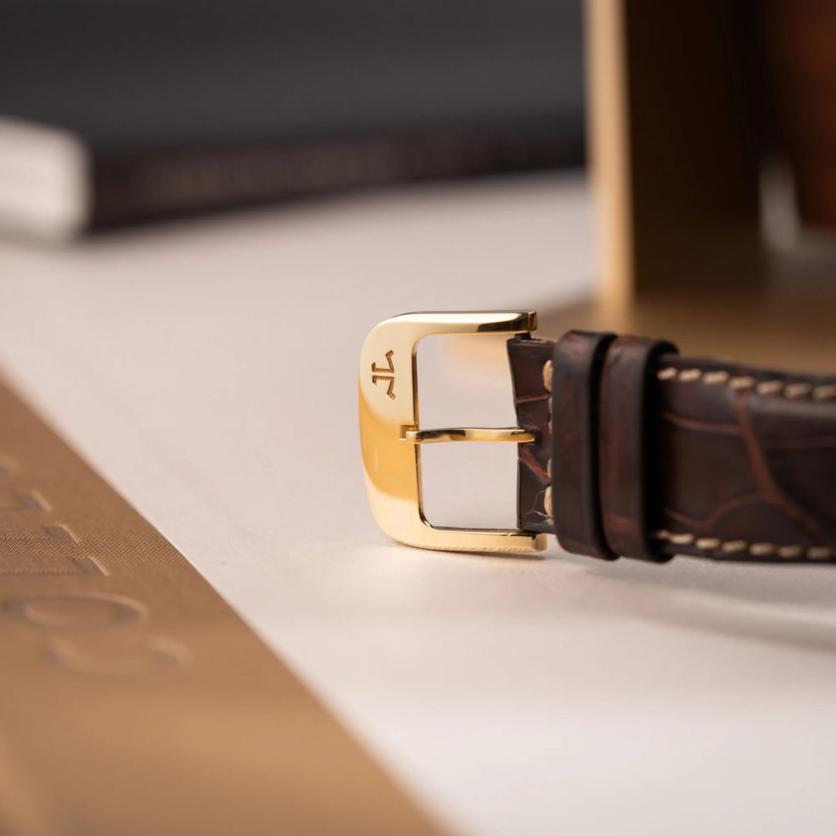Detailaufnahme der goldenen Dornschliesse derr Jaeger-LeCoultre Reverso Grande Date der Referenz 240.1.15 mit einem Gelbgold-Gehäuse am braunen Lederband