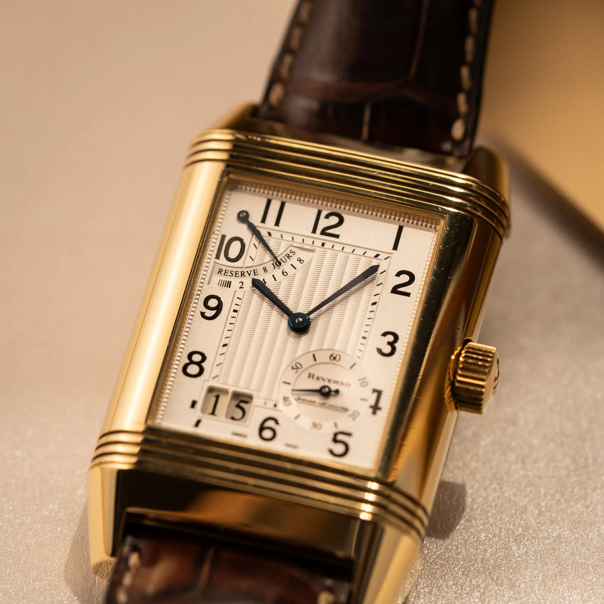 Detailaufnahme der Jaeger-LeCoultre Reverso Grande Date der Referenz 240.1.15 mit einem Gelbgold-Gehäuse am braunen Lederband