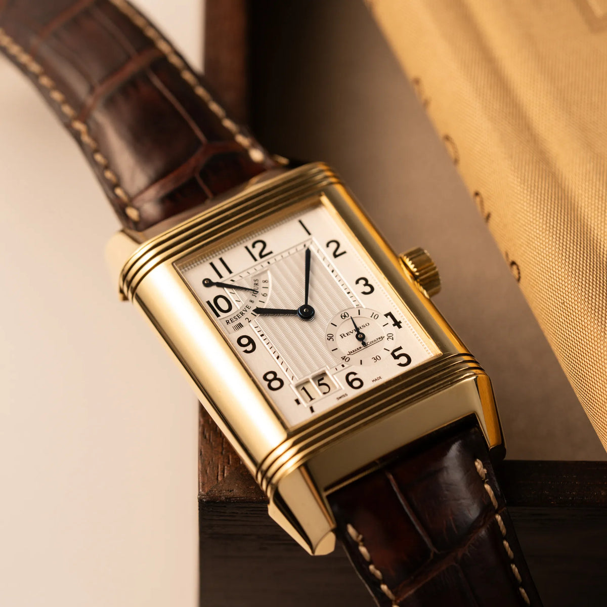 Produktfotografie der Jaeger-LeCoultre Reverso Grande Date der Referenz 240.1.15 mit einem Gelbgold-Gehäuse am braunen Lederband