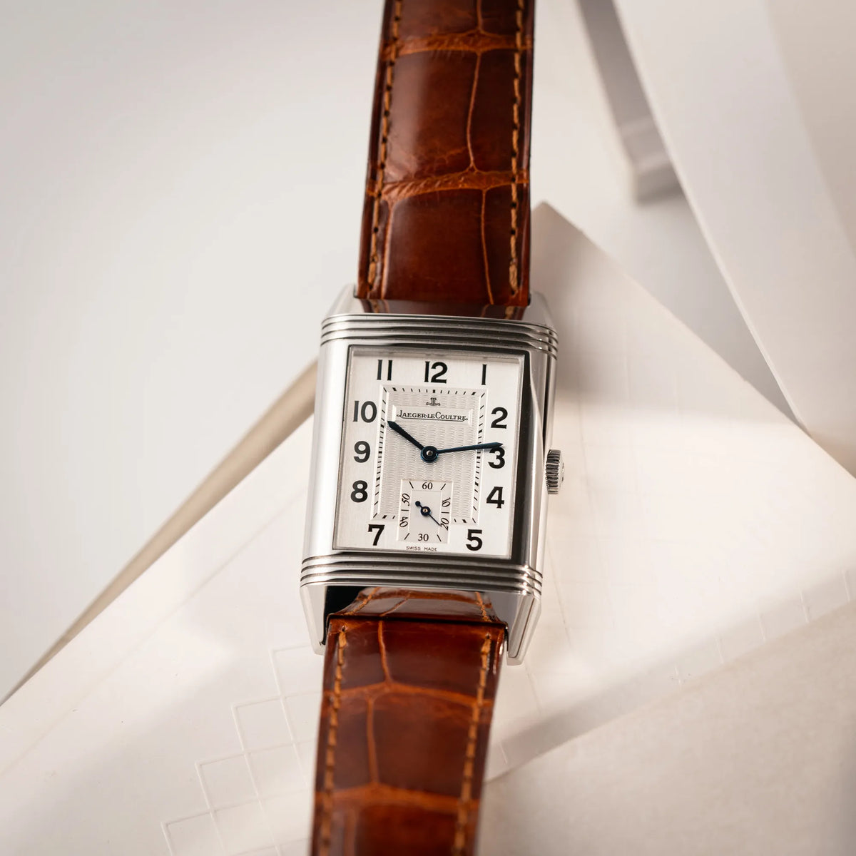 Produktfotografie der Jaeger-LeCoultre Reverso Grande Taille der Referenz 270.8.62 mit einem teil-guillochiertem, silberfarbenem Zifferblatt an einem braunem Lederband an seinem Handgelenk