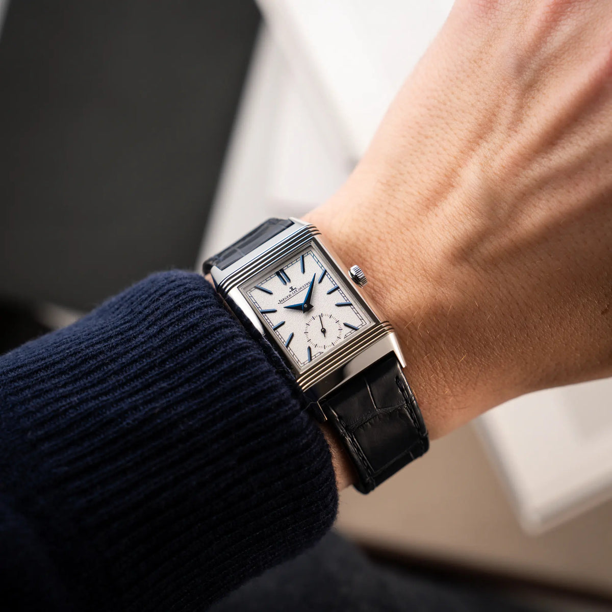Wristshot mit der Jaeger-LeCoultre Reverso Tribute Duoface Q3908420 an einem dunkelblauen Lederband