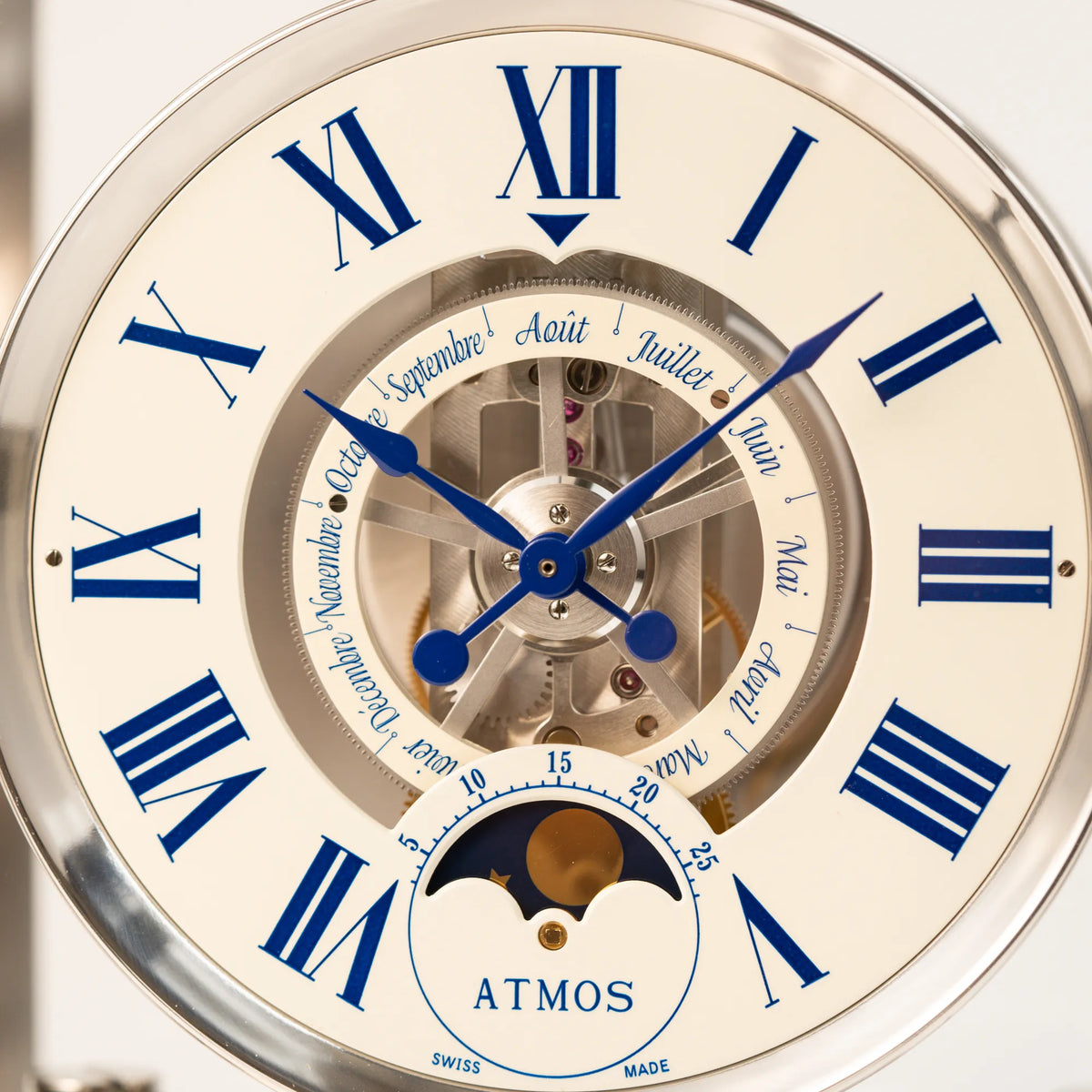 Makroaufnahme der Jaeger-LeCoultre Atmos Mondphase Tischuhr in rhodiniertem Stahl mit weißem Zifferblatt und blauen römischen Indizes