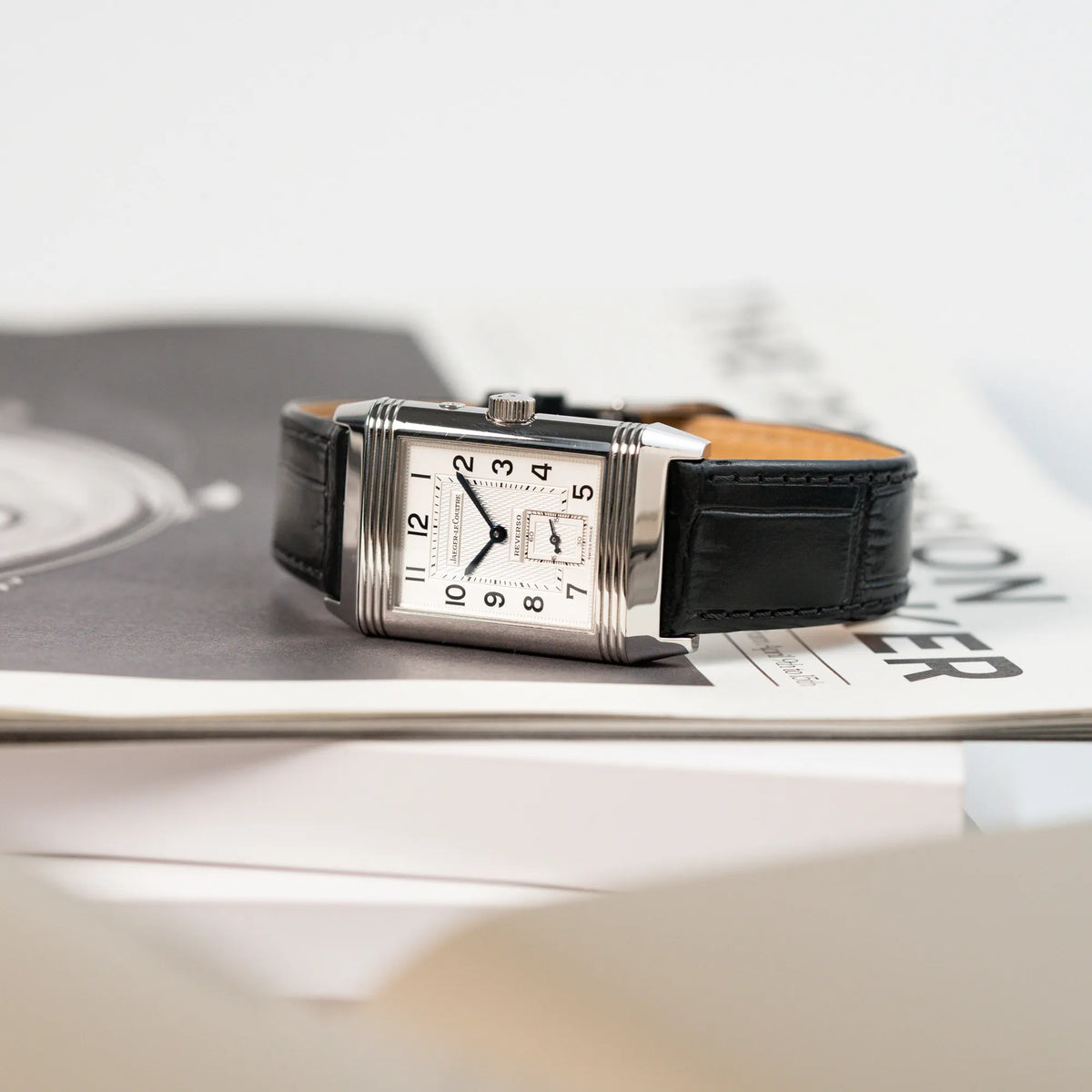 Produktfotografie der liegenden Jaeger LeCoultre Reverso Duoface 270.8.54 in Stahl mit Blick auf das weiße Zifferblatt