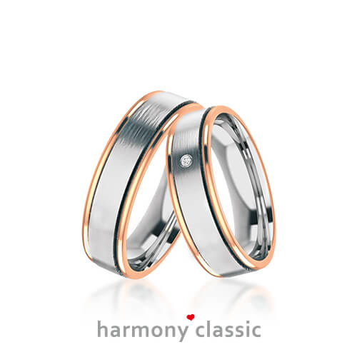 Produktfotografie des Trauringpaars Harmony Classic in Weißgold mit zwei roségoldenen Streifen, mit Diamant im Damenring