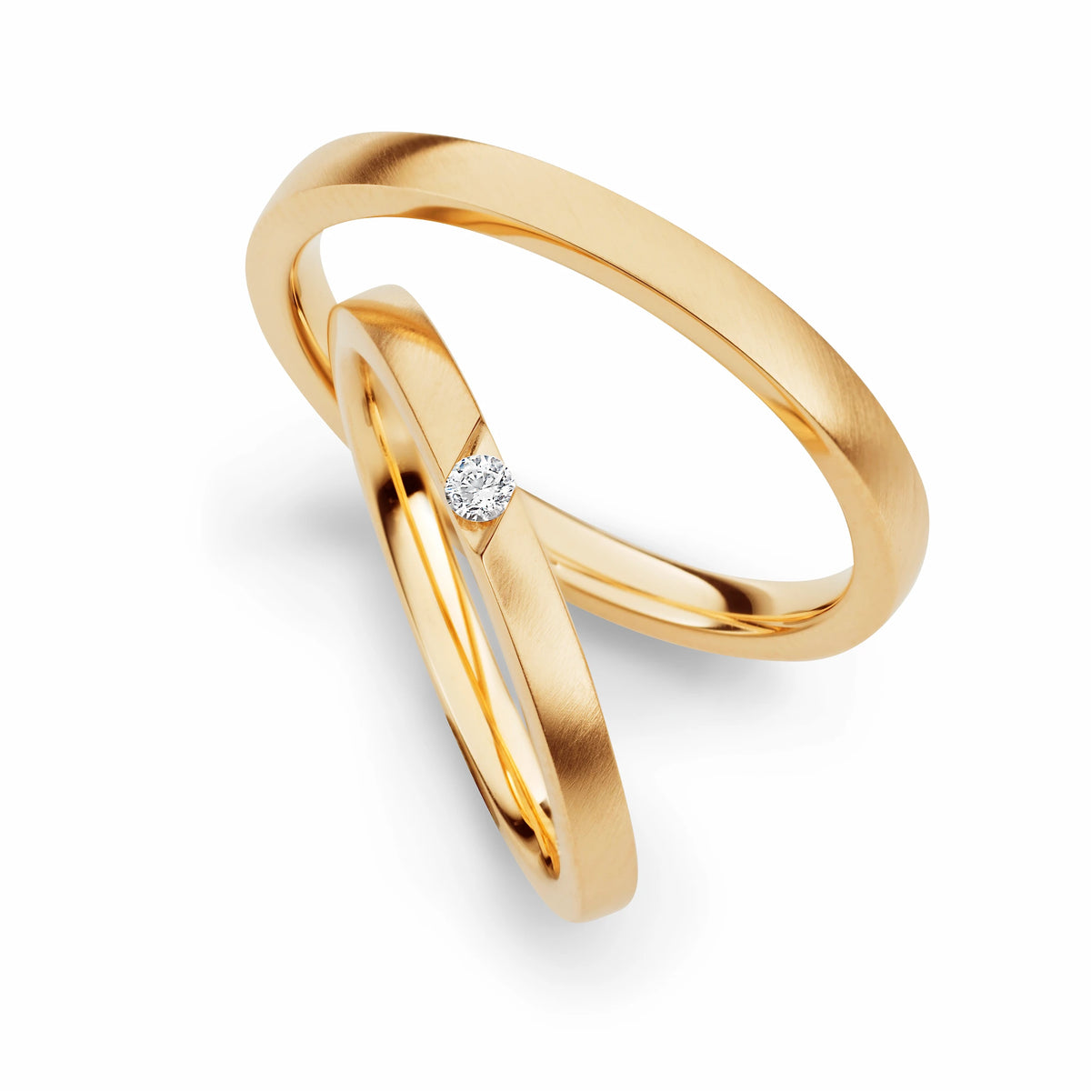 Produktfotografie des gelbgoldenen Max Kemper Trauringpaars mit einem sehr modern gefassten Brillanten mit einem kantigen Einschnitt in die Ringschiene