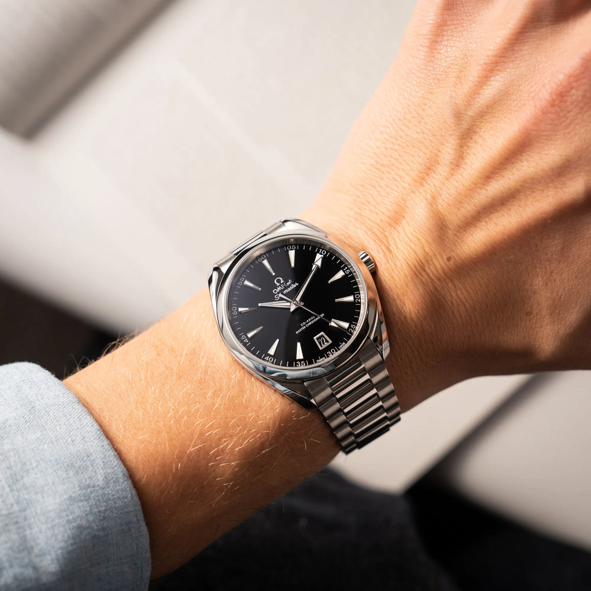 Mann trägt die Omega Seamaster Aquaterra 220.10.41.21.01.002 mit 41 mm Gehäuse und schwarzem Lack-Zifferblatt für einen Wirstshot an seinem Handgelenk