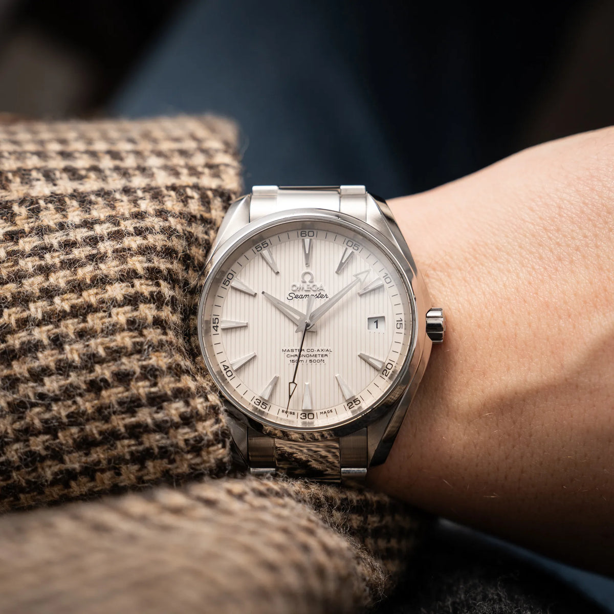 Wristshot mit der Omega Seamaster Aqua Terra 150M mit 41mm-Gehäuse und einem weißen Zifferblatt mit vertikal verlaufenden Linien