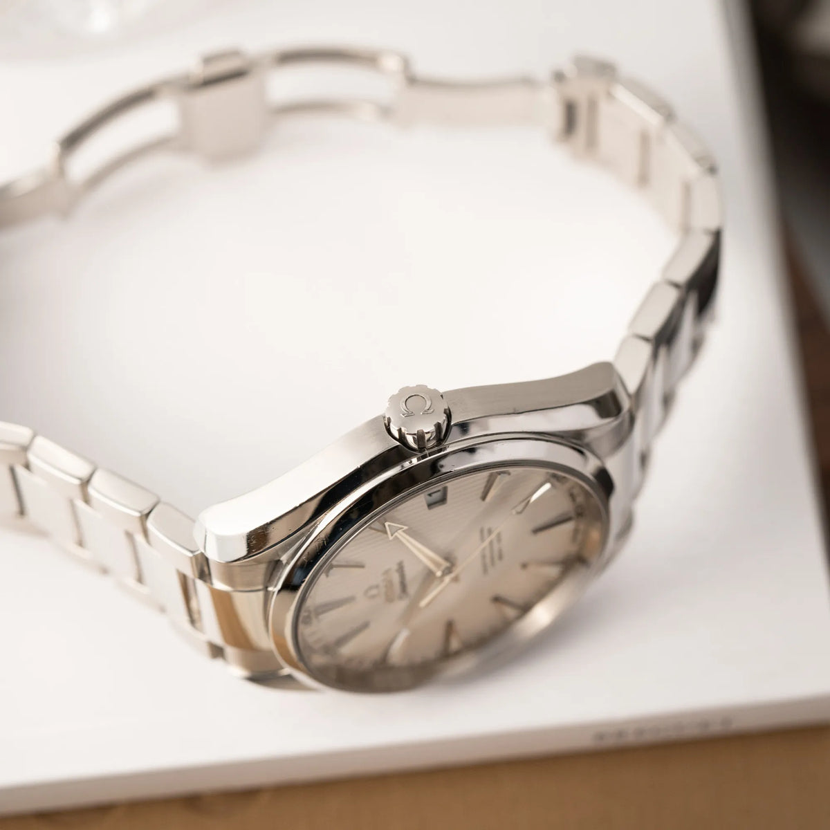 Produktfotografie zeigt die seitliche Gehäuseflanke der Omega Seamaster Aqua Terra 150M mit 41mm-Gehäuse und einem weißen Zifferblatt mit vertikal verlaufenden Linien