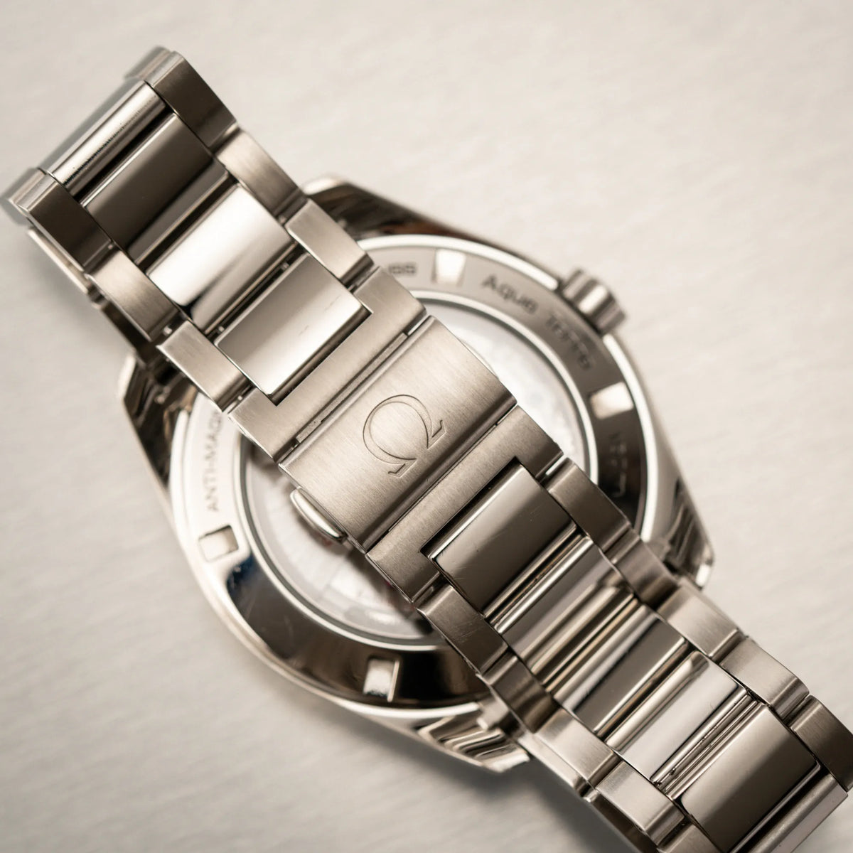 Geschlossene Doppelfaltschliesse mit Omega-Logo von der Omega Seamaster Aqua Terra 150M mit 41mm-Gehäuse und einem weißen Zifferblatt mit vertikal verlaufenden Linien