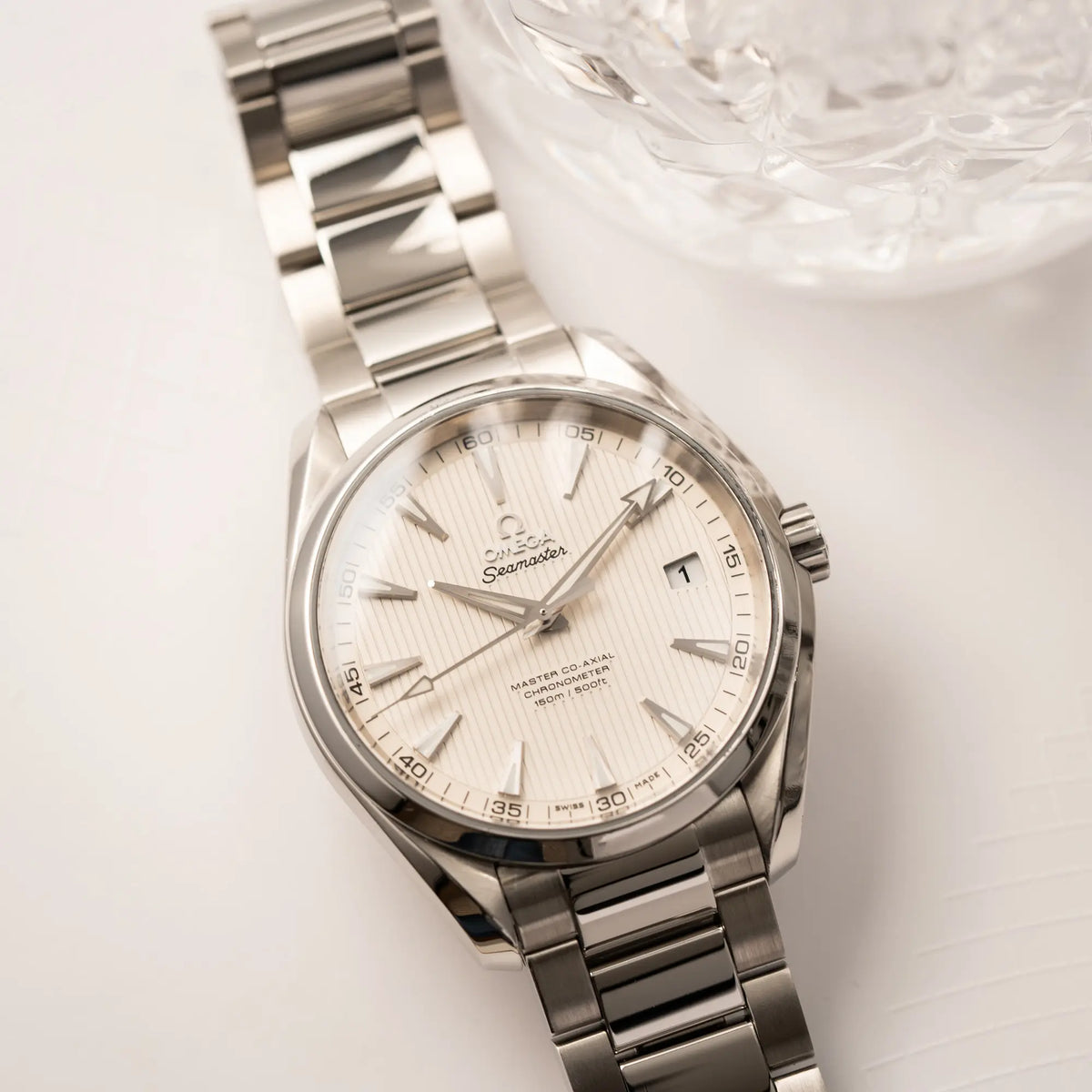 Produktfotografie der Omega Seamaster Auqua Terra 150M mit 41mm-Gehäuse und einem weißen Zifferblatt mit vertikal verlaufenden Linien