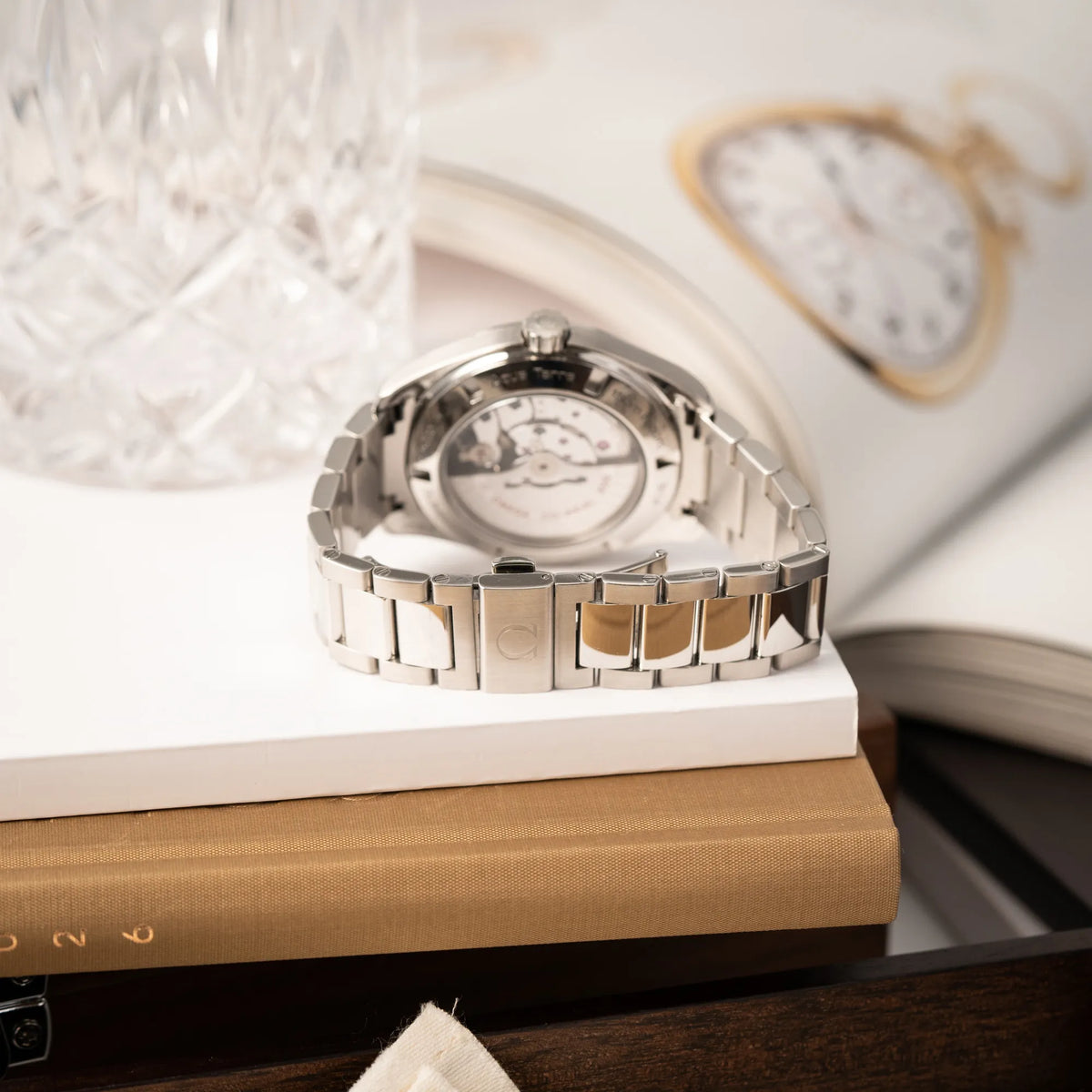 Produktfotografie zeigt Band und Schliesse der Omega Seamaster Aqua Terra 150M mit 41mm-Gehäuse und einem weißen Zifferblatt mit vertikal verlaufenden Linien