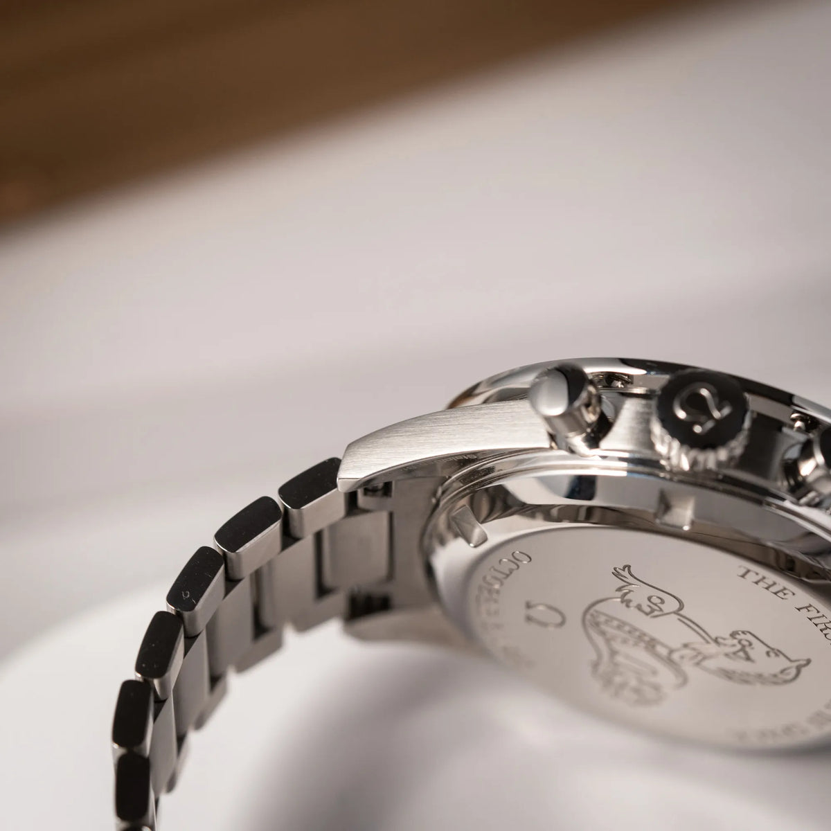 Detailaufnahme des rechten unteren Bandanstoßes der Omega Speedmaster FOIS der Referenz 310.30.40.50.06.001 mit dem dunkelblauen Zifferblatt mit dunkel-beigen Indizes im Vintage-Look und einem vom Standard-Modell abgeänderten Stahl-Armband, was beides an das klassische Speedy-Modell erinnert