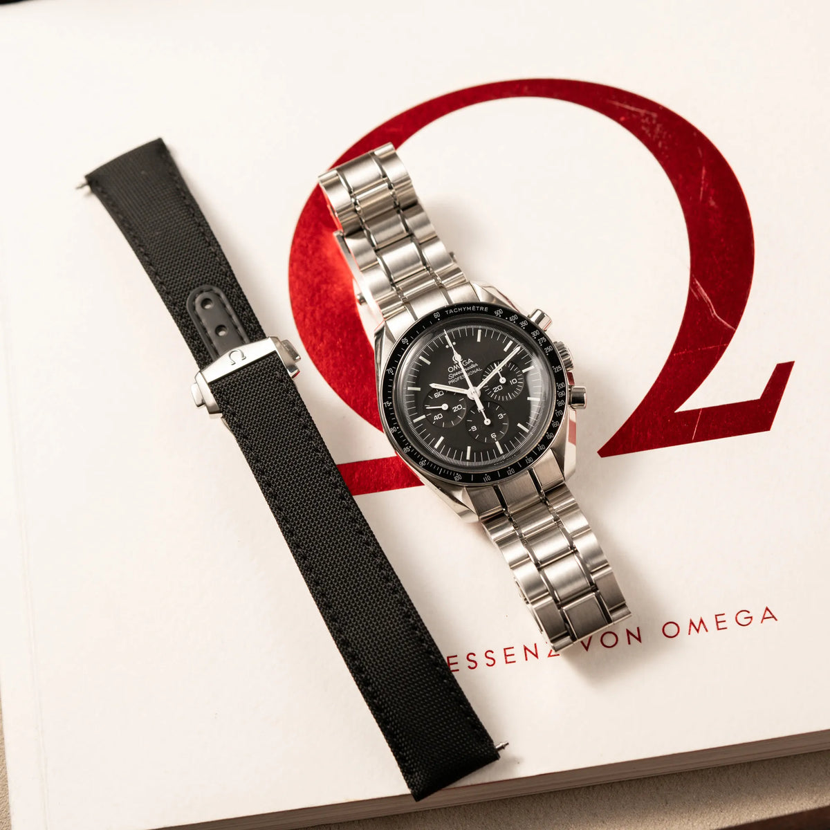 Omega Speedmaster Professional Moonwatch der Referenz 311.30.42.30.01.005 in einem 42mm-Gehäuse mit klassischem schwarzen Zifferblatt und verbautem Hesalitglas zusammen mit dem zusätzlichen original Omega Nato-Strap
