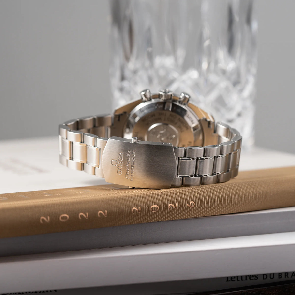 Produktfotografie der Omega Speedmaster Professional Moonwatch der Referenz 311.30.42.30.01.005 in einem 42mm-Gehäuse mit klassischem schwarzen Zifferblatt und verbautem Hesalitglas zeigt den Zustand des Edelstahl-Armbands und der originalen Omega-Faltschliesse