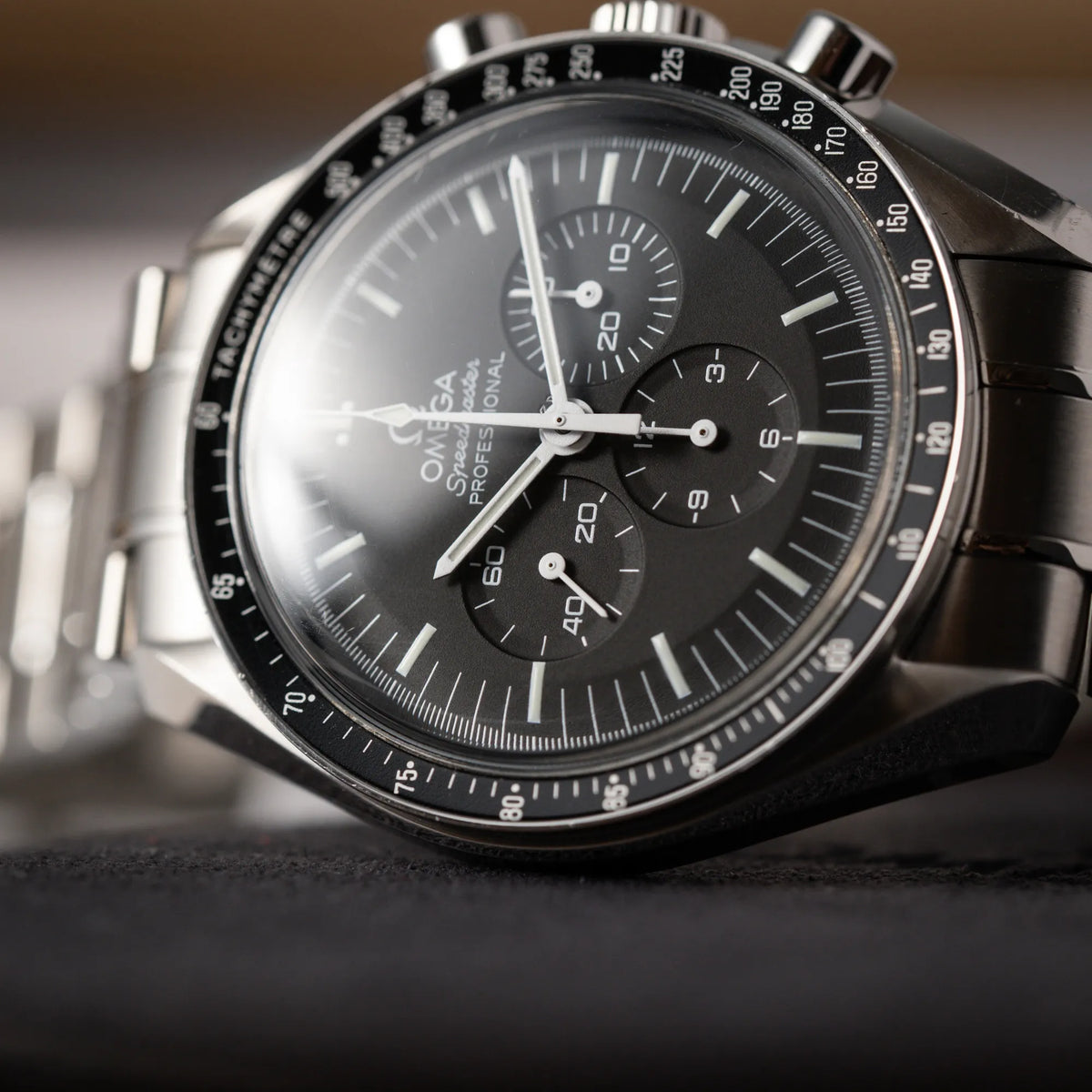 Detailaufnahme der Omega Speedmaster Professional Moonwatch der Referenz 311.30.42.30.01.005 in einem 42mm-Gehäuse mit klassischem schwarzen Zifferblatt und verbautem Hesalitglas