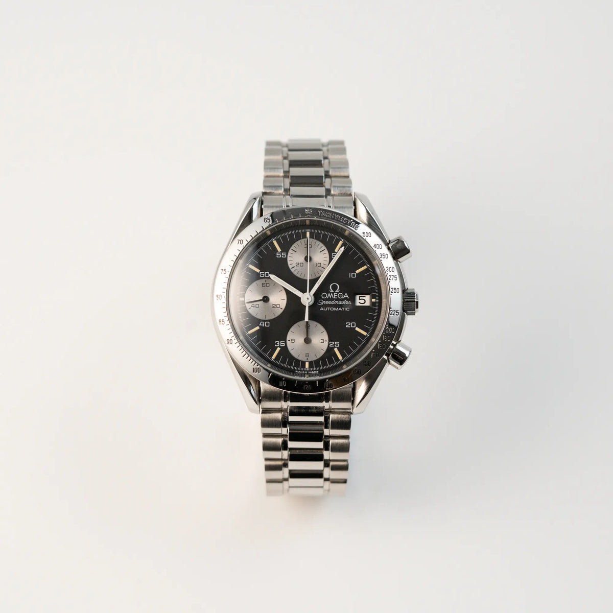 Frontale Ansicht der Omega Speedmaster Automatic Date mit schwarzem Zifferblatt und silbernen Totalisatoren
