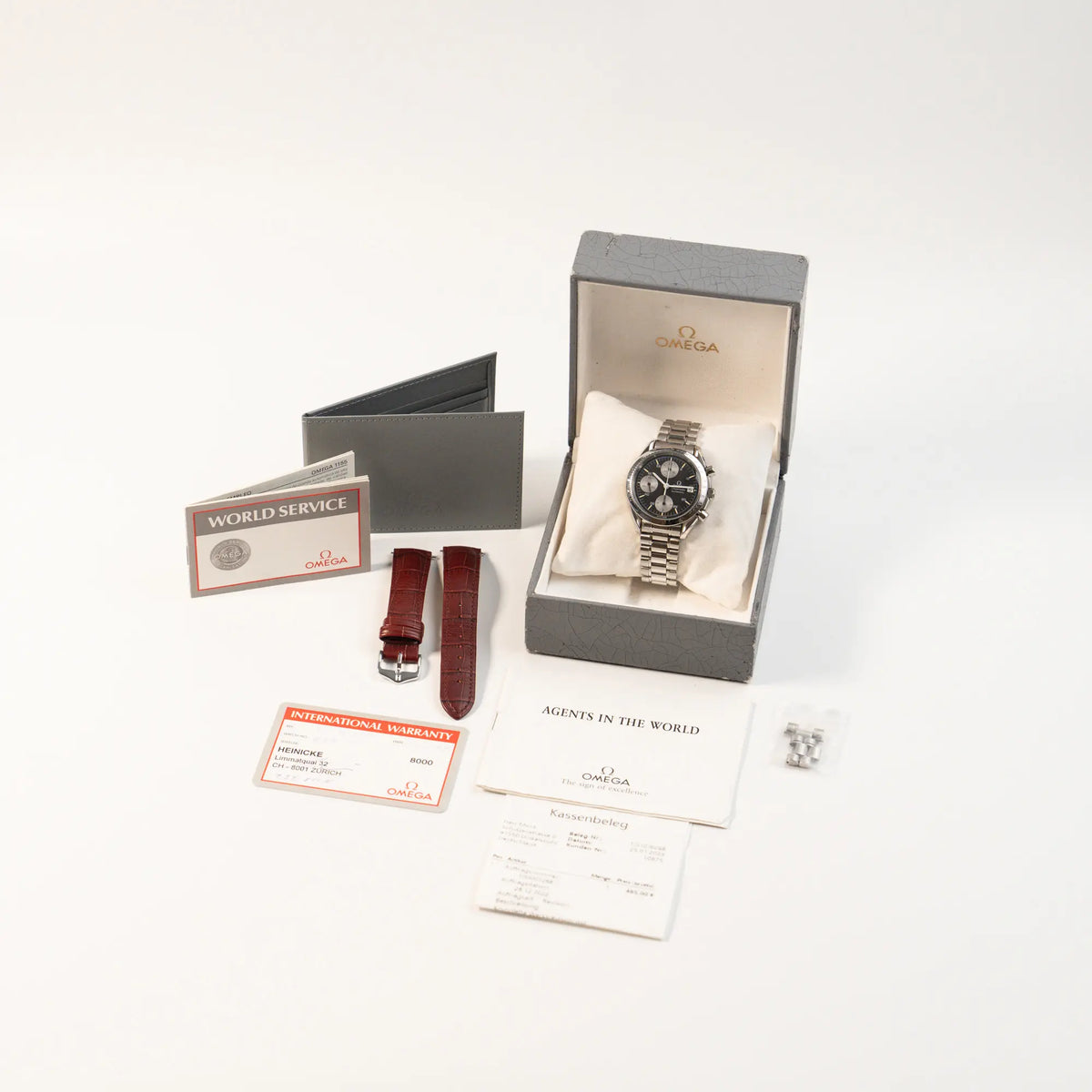 Omega Speedmaster Automatic Date mit schwarzem Zifferblatt und silbernen Totalisatoren zusammen mit dem Lieferumfang, betsehend aus Box, Garantiekarte, Booklets
