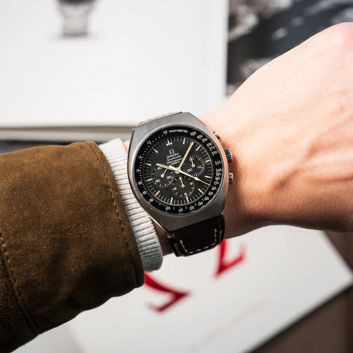 Wristshot mit der Omega Speedmaster Moonwatch Mark 2 an einem braunen Lederarmband