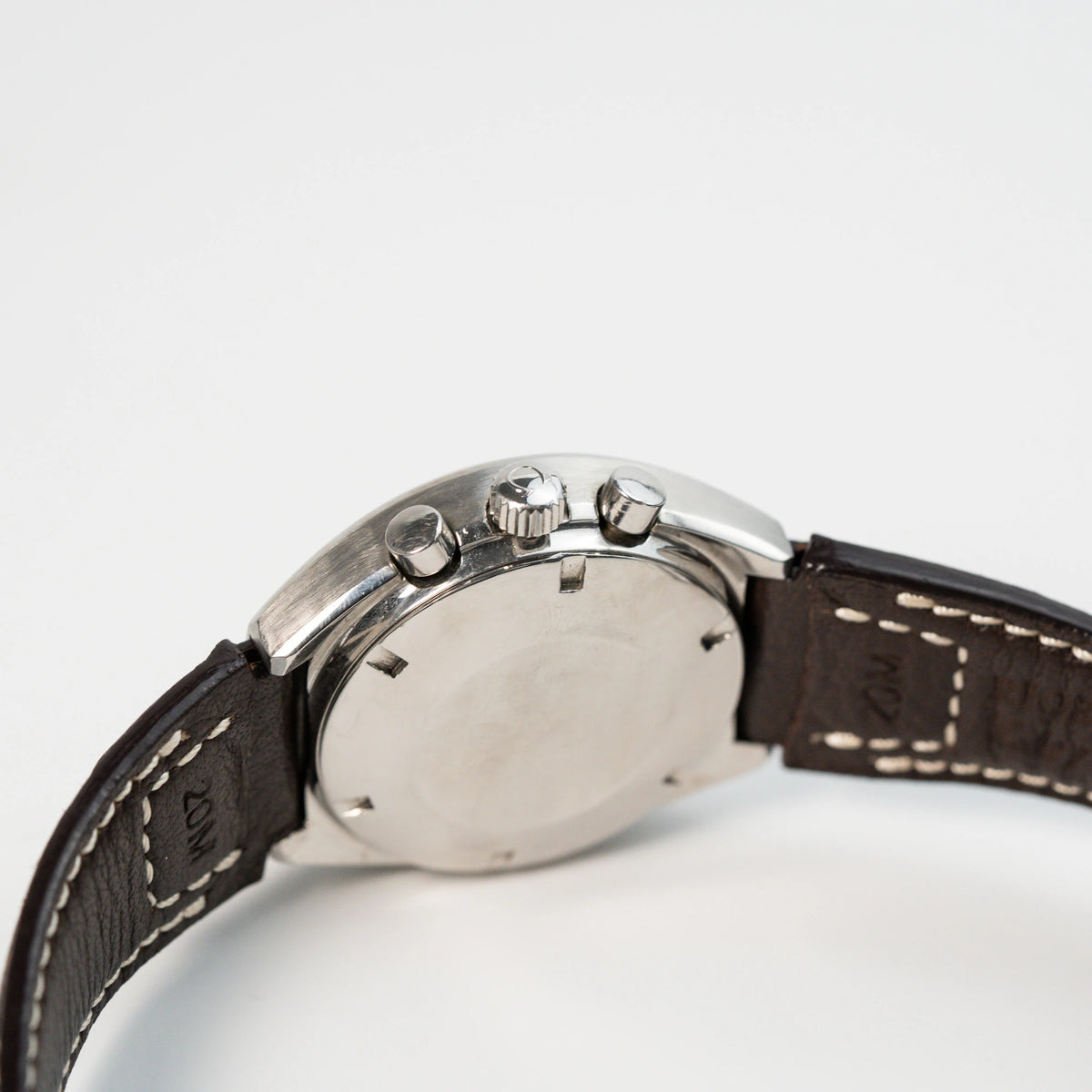 Seitliches Gehäuse mit Blick auf die Krone und die Chronograph-Pusher der Omega Speedmaster Moonwatch Mark 2 an einem braunen Lederarmband